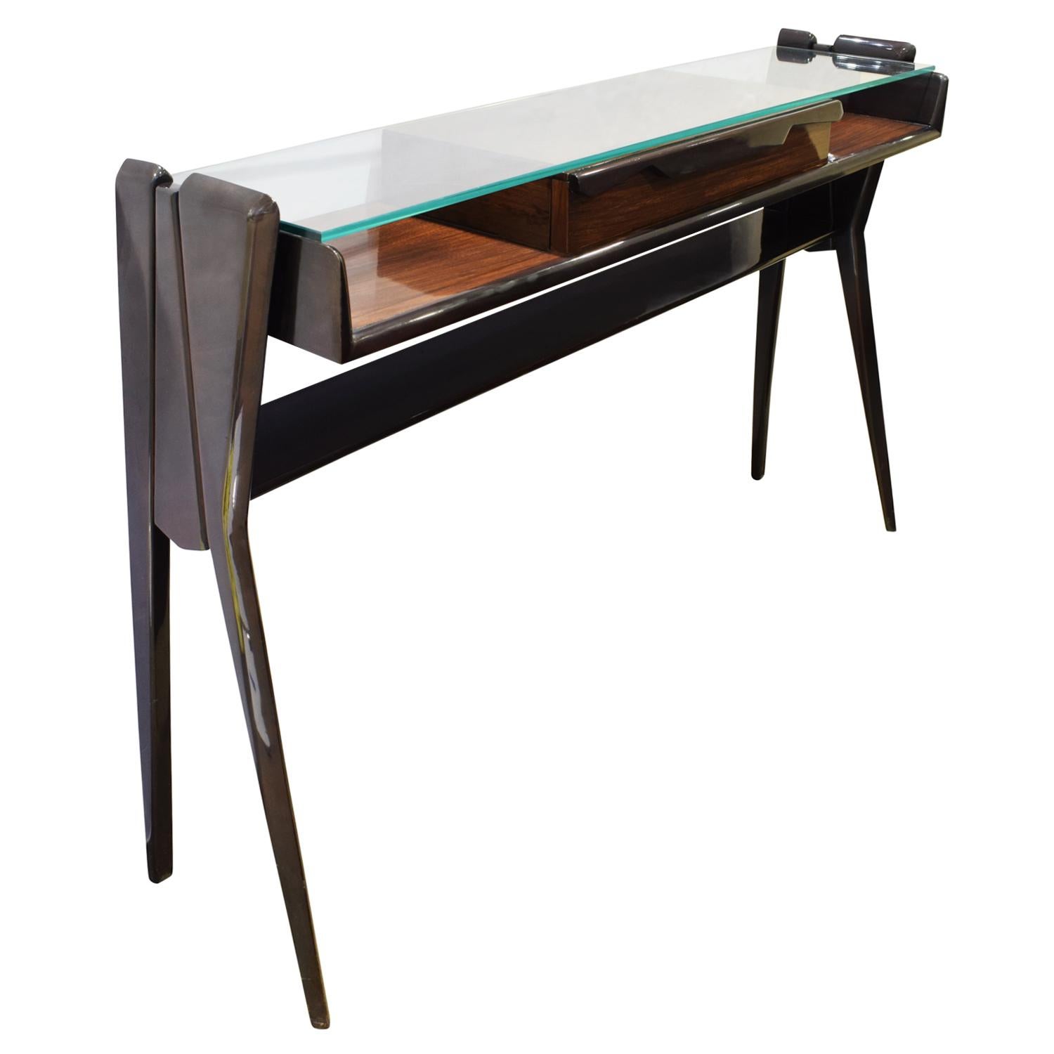 Sculptural console table in dark walnut, narrow with single drawer and glass top, Italian 1950's (signed on bottom “Mobili Pennati Egidio”). This is a very elegant console table.