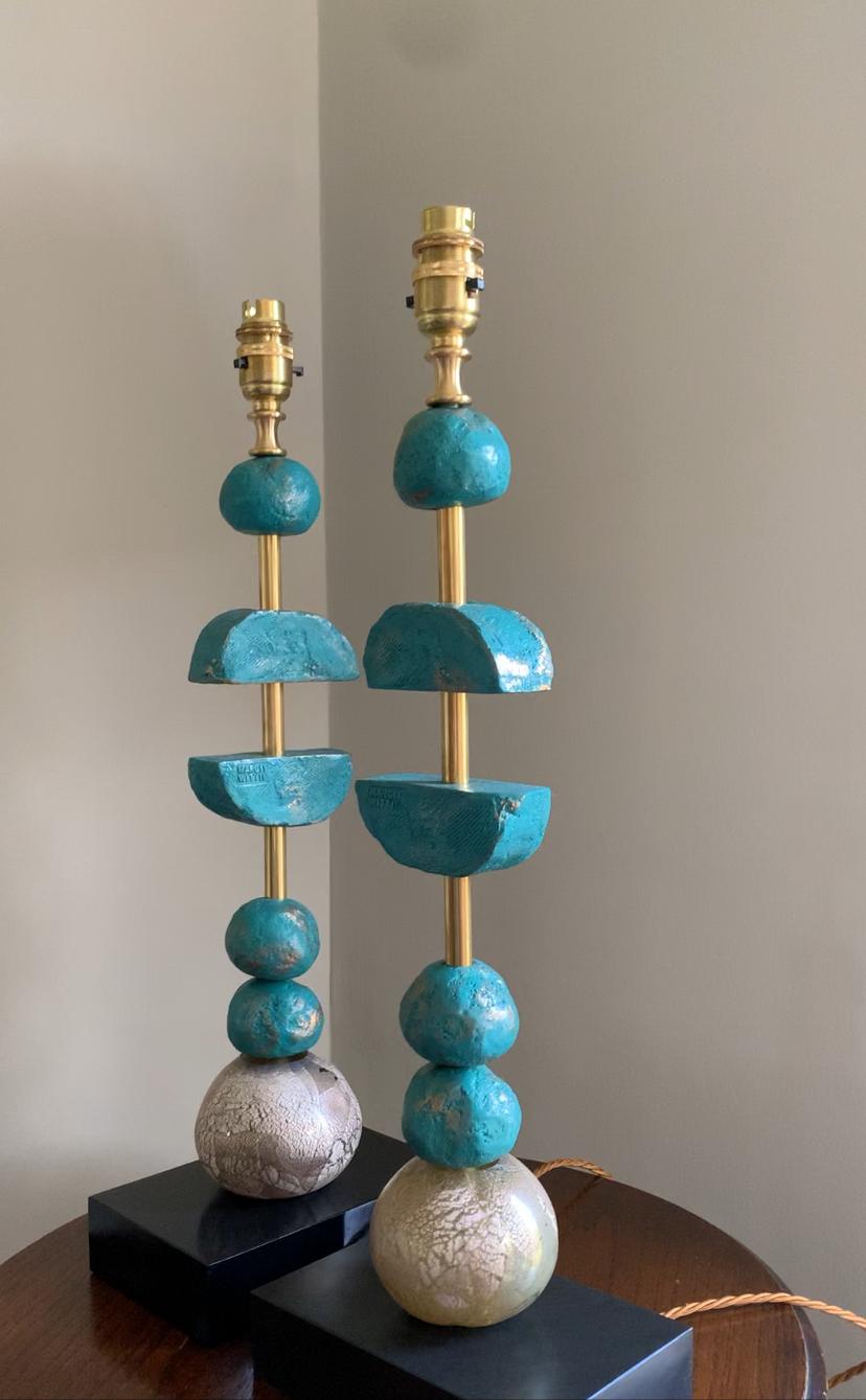 These sculptural contemporary Margit Wittig table lamps are mounted on rectangular slate bases and feature multiple turquoise/ teal coloured handcrafted components, spheres and semi-circles with organic surface textures. The large glass spheres are
