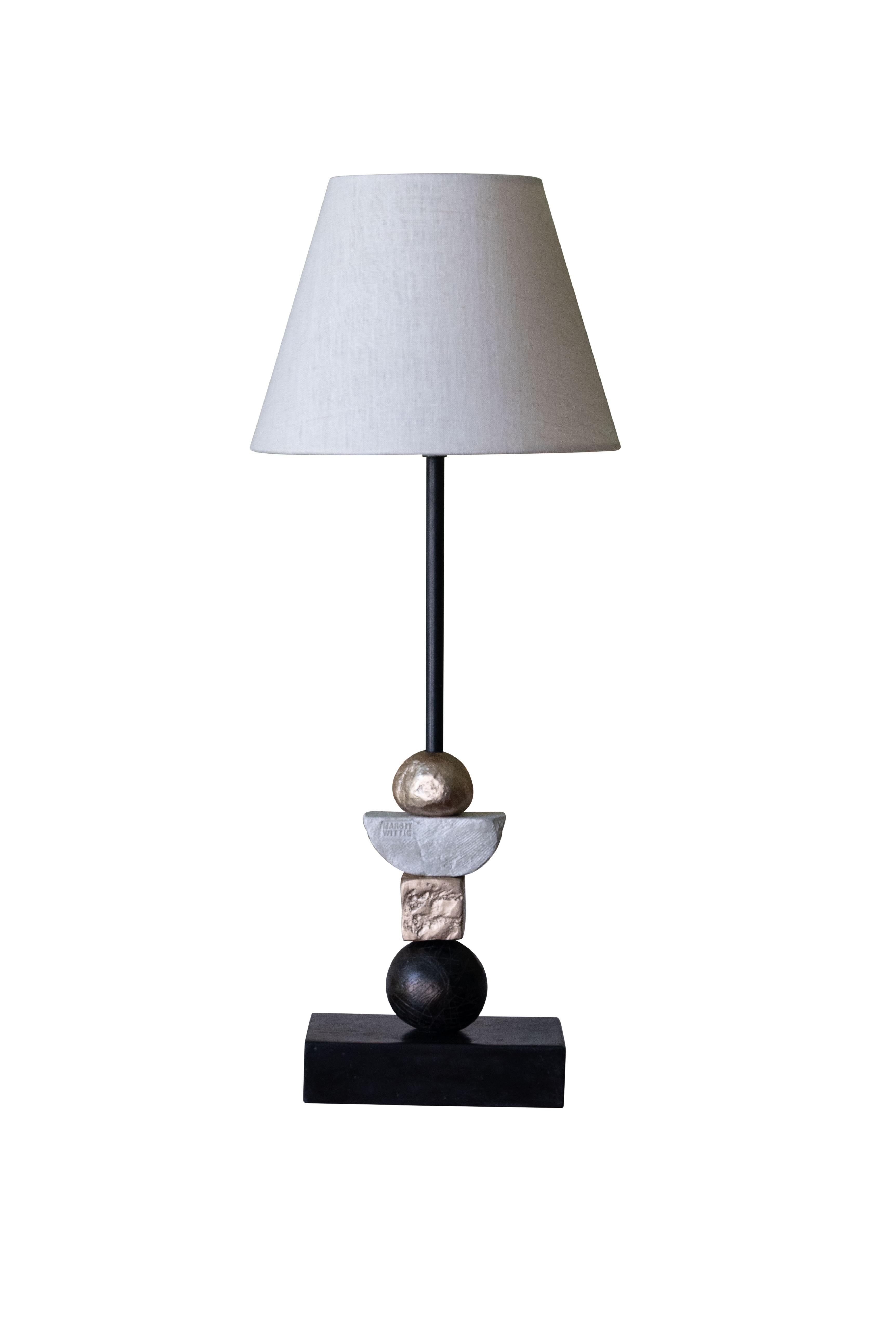 This contemporary monochromatic Margit Wittig table lamp is mounted on a slate base and features multiple resin handcrafted resin components. Each element is cast and patinated to increase tonal contrast and enhance the surface texture. The 22-karat