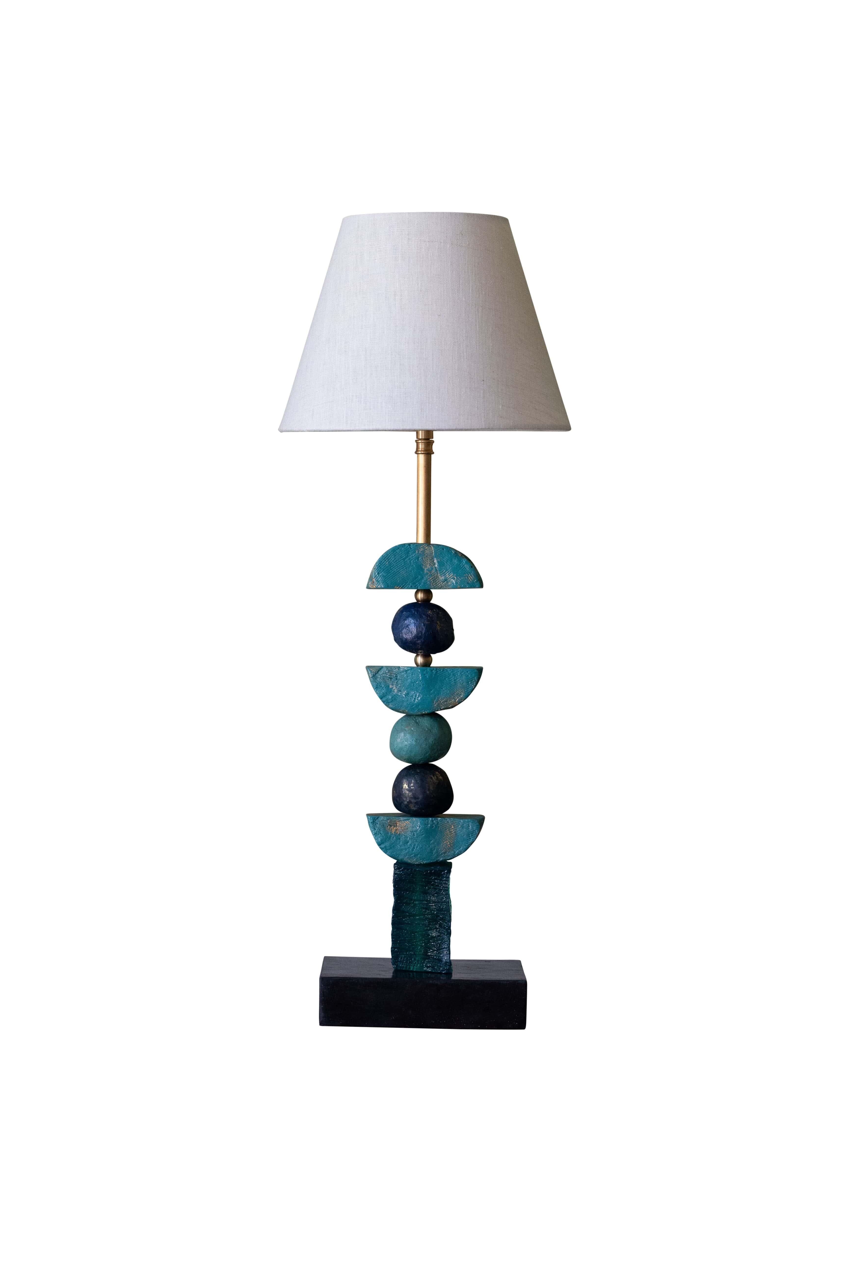Cette lampe de table contemporaine de Margit Wittig repose sur une base rectangulaire en ardoise et comprend des sphères coulées à la main en bleu et des demi-lunes en sarcelle. Les éléments contemporains sculptés, avec leur texture organique, sont