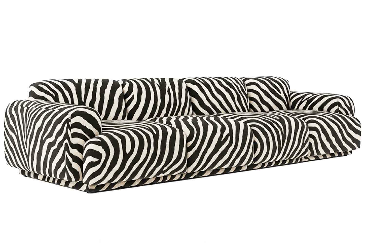 Sofa with zebra-patterned fabric upholstery. 

Abundancia Sofa is a refusal to shrink. A refusal to sit small.  It’s a four-meter-long declaration of comfort as power.  Massive, unapologetic, and made to hold all your weight—physical, emotional,
