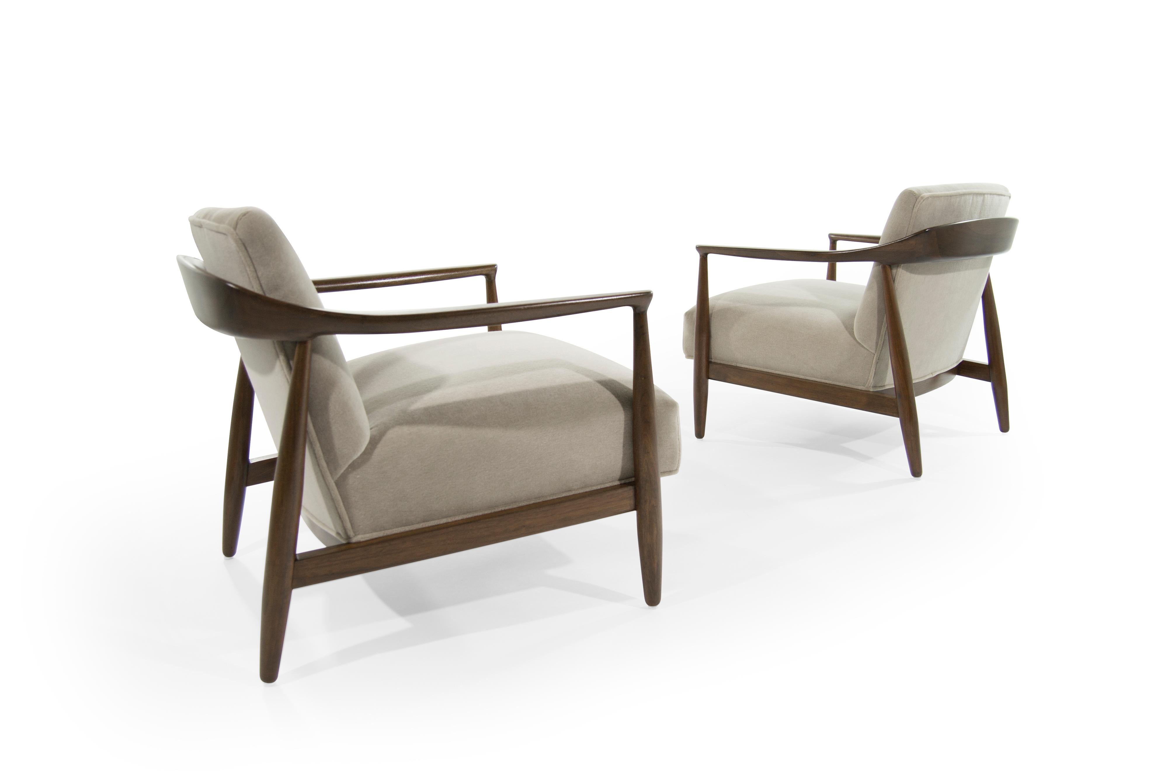 Set of lounge chairs in the style of Ib Kofod-Larsen, Denmark, circa 1950s. Sculptural walnut frames fully restored. Newly upholstered in natural alpaca velvet.