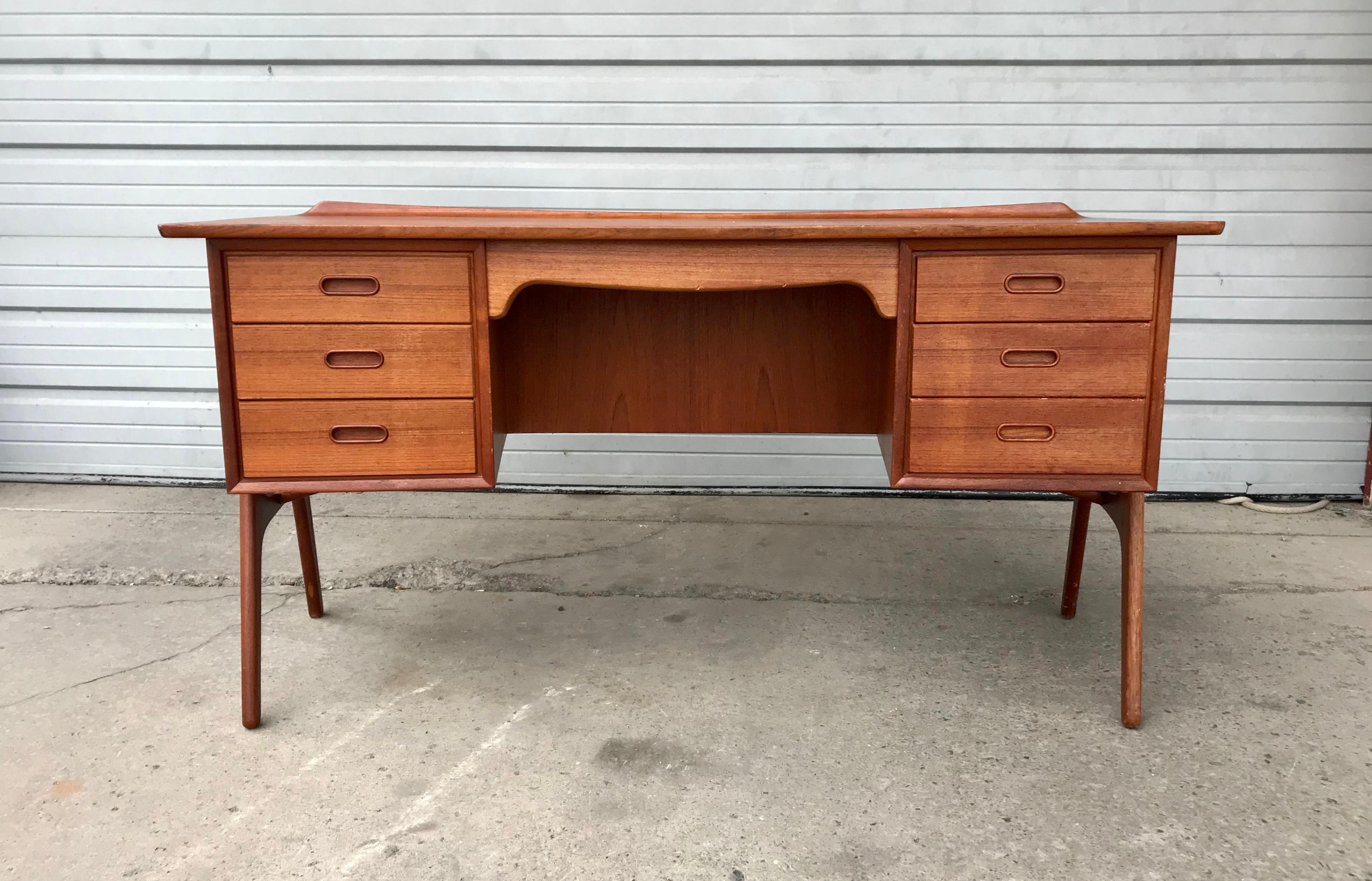 Classic Scandinavian teak desk, model SH 180, by Svend Madsen for Sigurd Hansen.

Svend Aage Madsen designed this teak desk, model SH 180, for Sigurd Hansen Møbelfabrik in the early 1960s. The curved case sits on a sculpted frame with contrasting