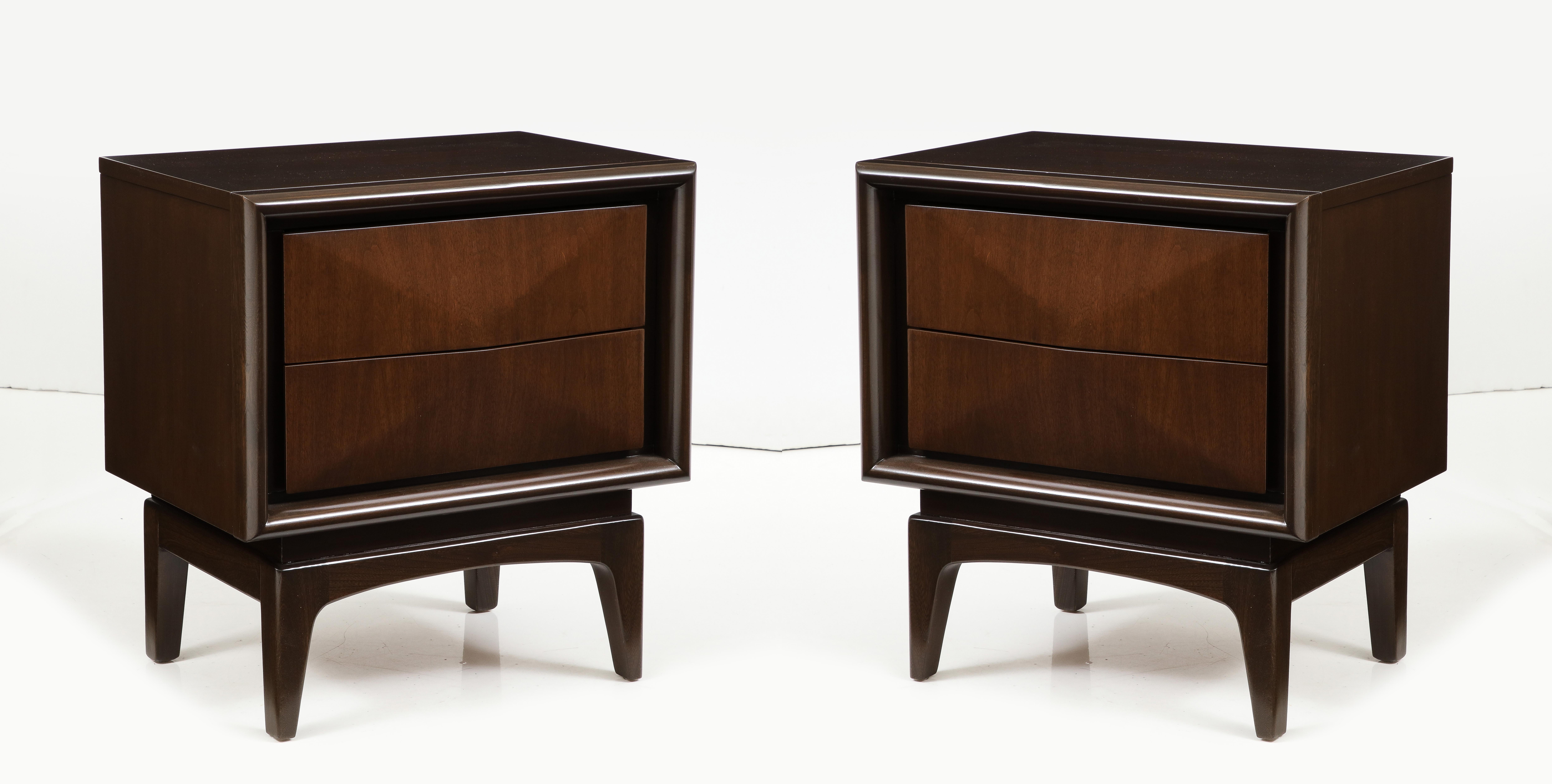 Pair of Mid Century diamond front Walnut nightstands featuring 2 drawers. Case sits upon sculptural splayed legs. Mint Restored condition in a medium brown stain.