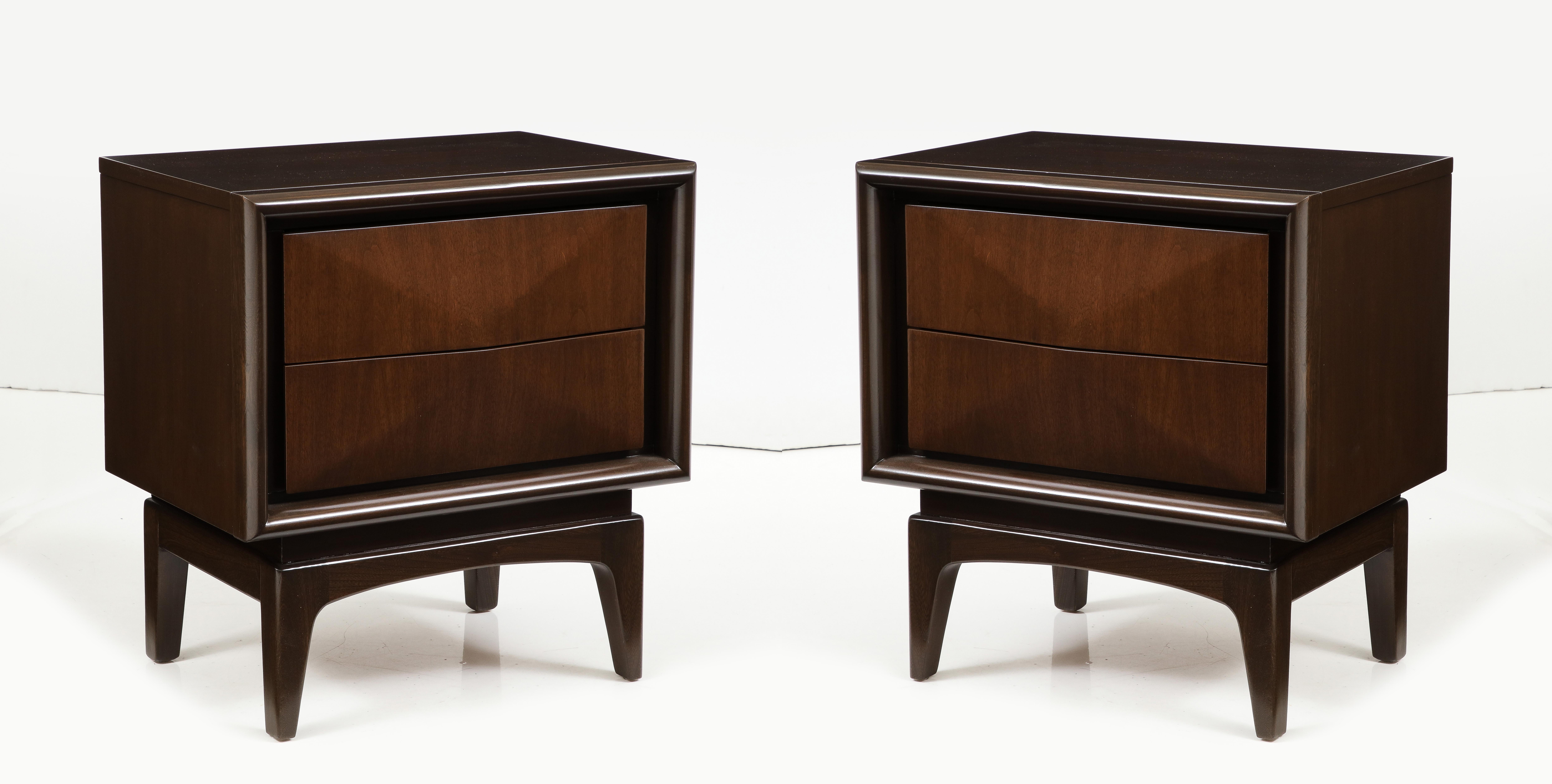 Pair of Mid Century diamond front Walnut nightstands featuring 2 drawers. Case sits upon sculptural splayed legs. Mint Restored condition in a medium brown stain.