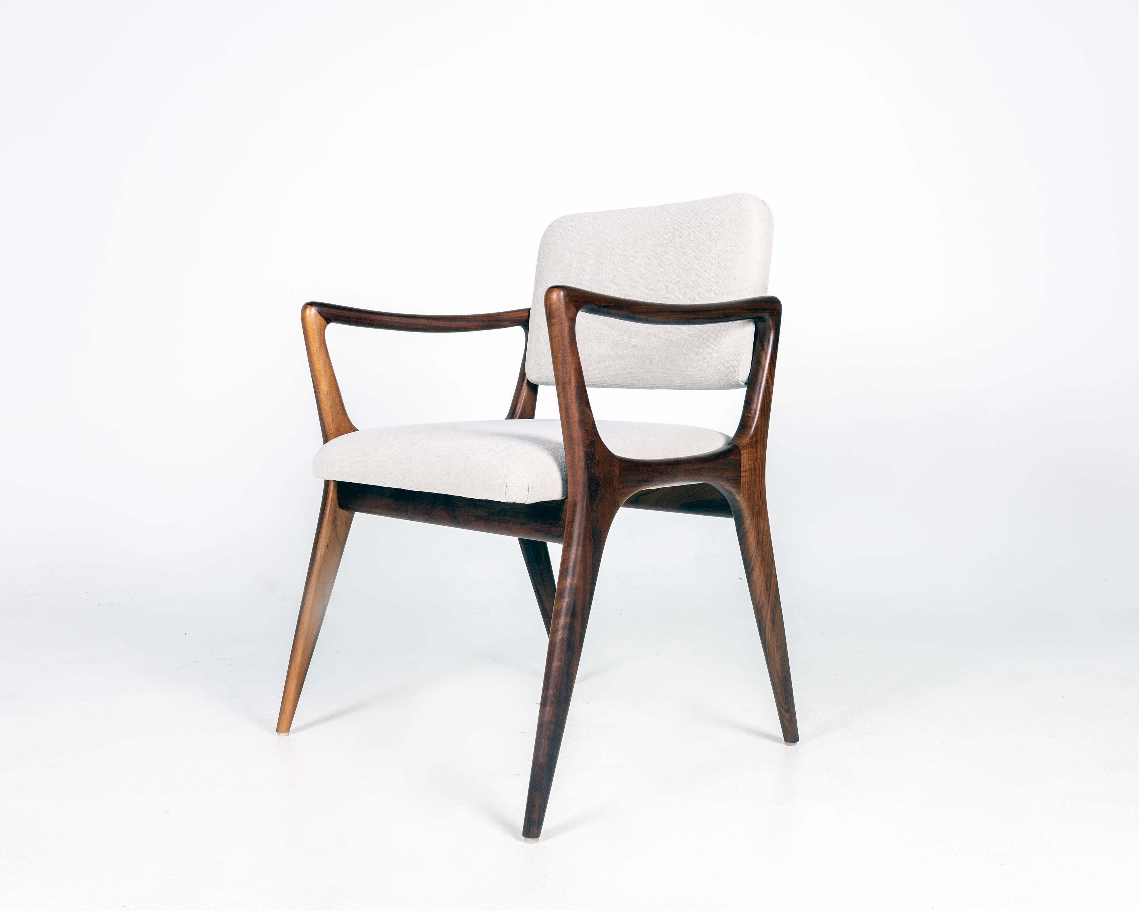 Sedie da pranzo scultoree personalizzate nello stile di Gio Ponti. Struttura in noce massiccio, schienali e sedute imbottiti. L'altezza del braccio è di 25,25