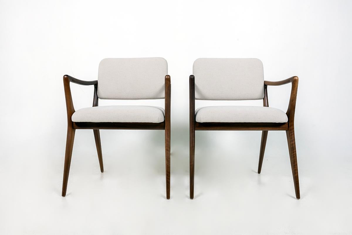 Sedie da pranzo scultoree personalizzate nello stile di Gio Ponti. Struttura in noce massiccio, schienali e sedute imbottiti. L'altezza del braccio è di 25,25