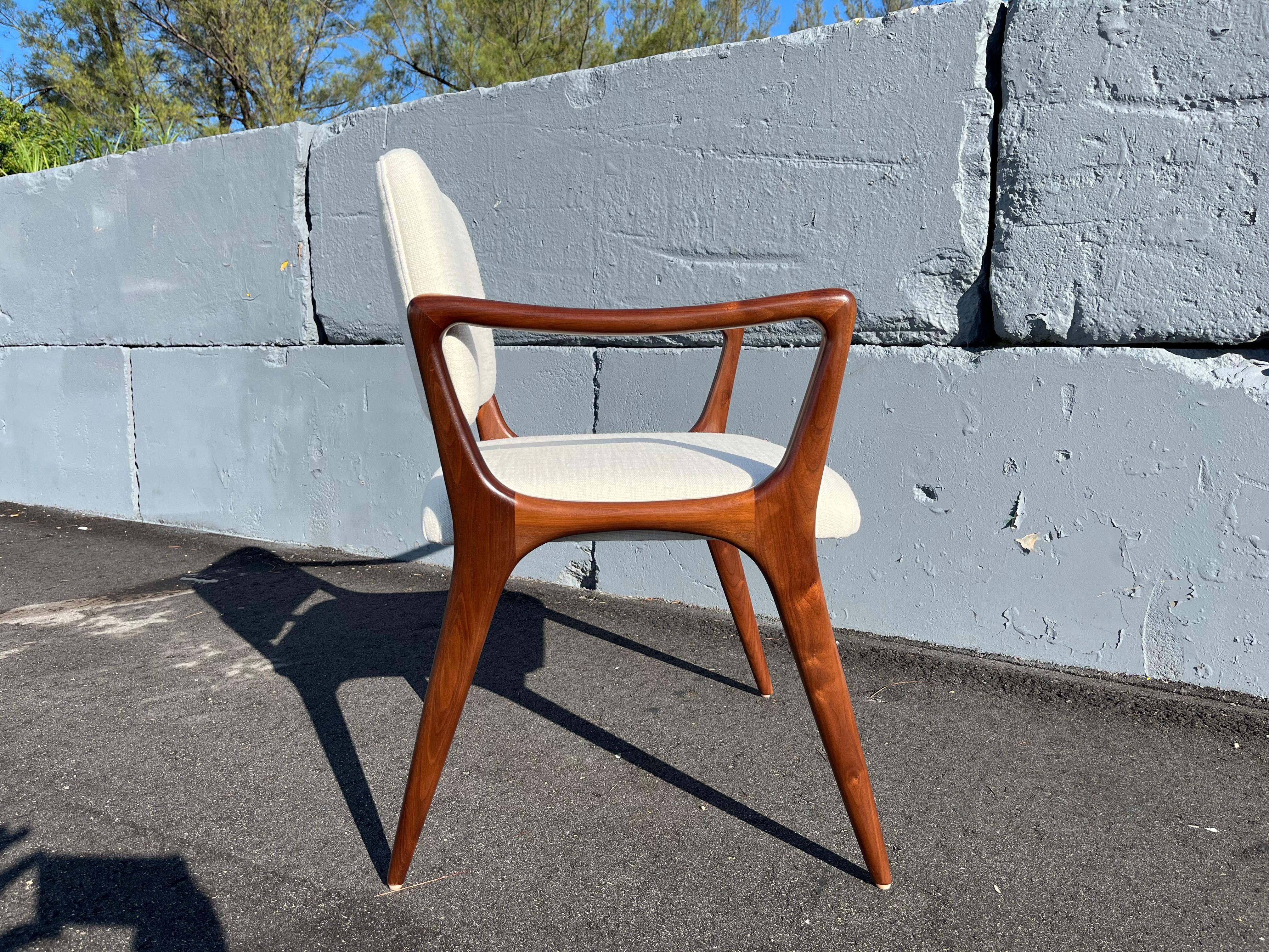 Custom Sculptural Dining Chairs in the style of Gio Ponti. Solid walnut frames, upholstered backs and seats. Arm height is 25.25”. Available seat height is 17.5