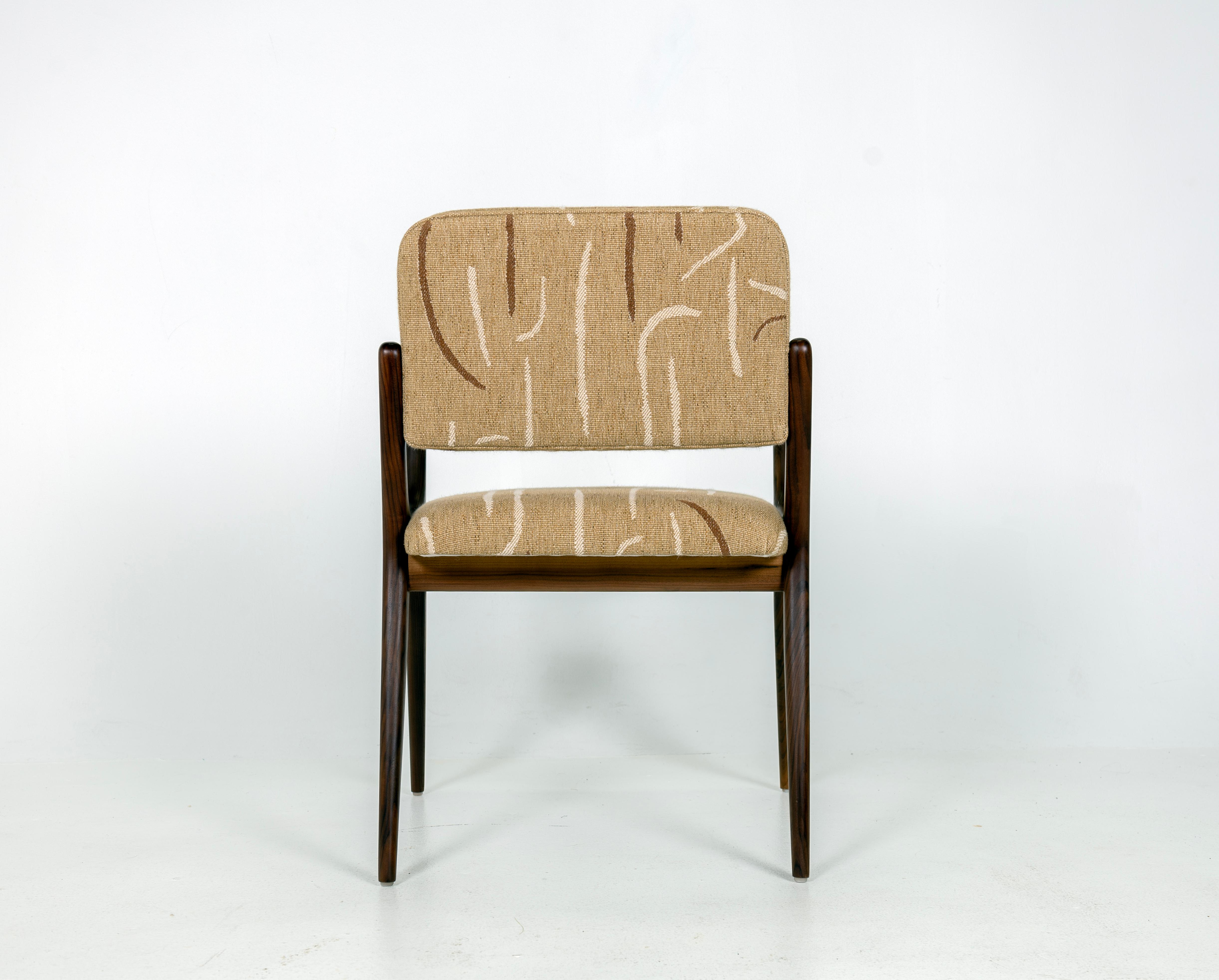 Skulpturaler Esszimmer- oder Schreibtischsessel im Stil von Gio Ponti. Massives Nussbaumholz, Sitz und Rückenlehne sind mit Conga Honey Fabric von Larsen bezogen. Arm Höhe ist 25,25