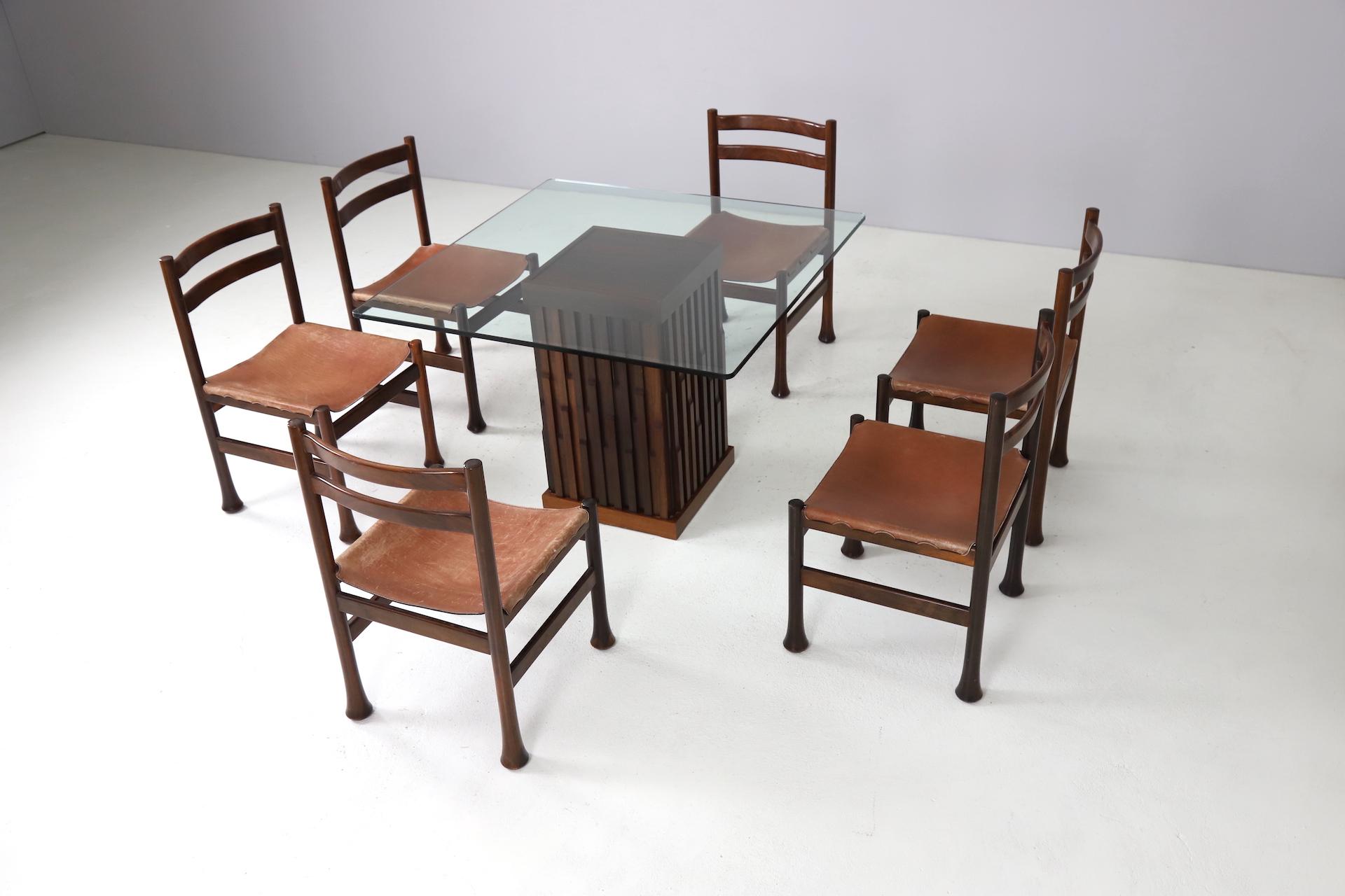 Sculptural dining room set designed by Luciano Frigerio. The chairs and table are made out of mahogany with a Brutalist look. The original saddle leather upholstery on the seats is without any defects and still very strong, over the years it