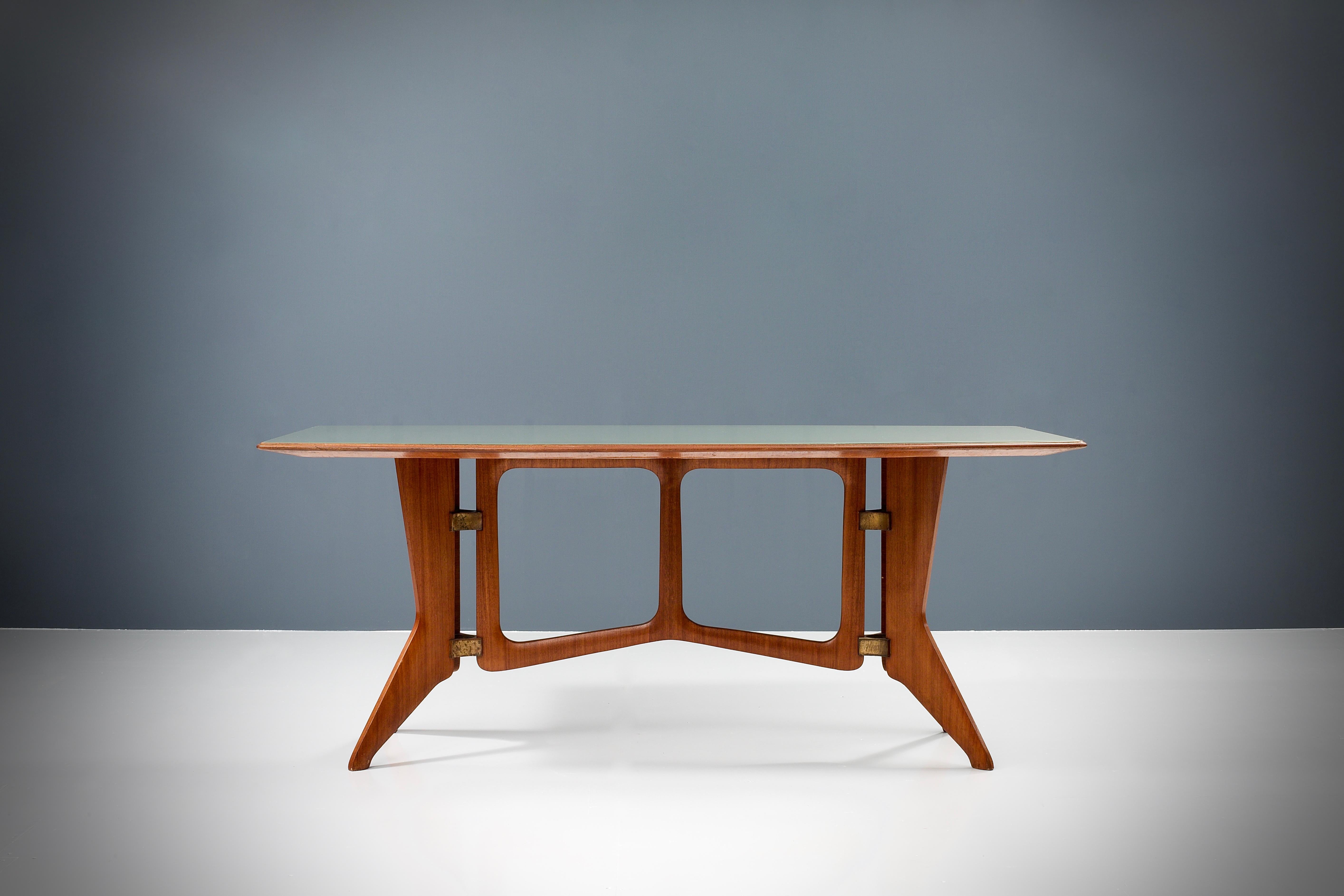 Table de salle à manger italienne sculpturale d'Ariberto Colombo avec un cadre en teck qui a magnifiquement vieilli au fil du temps. Le cadre est maintenu par des joints triangulaires incurvés en laiton, ce qui rend la table assez robuste mais