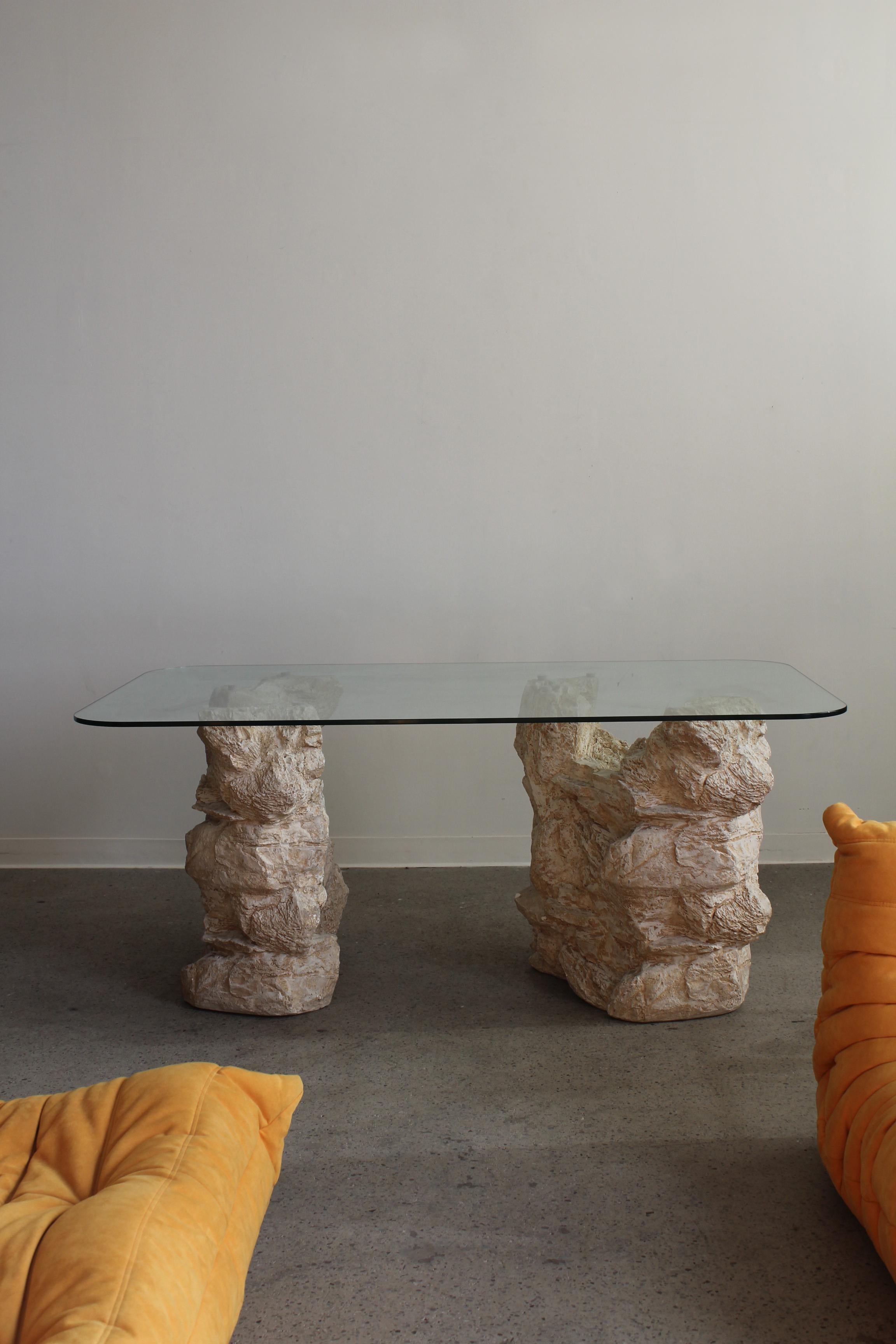 Glass Dining Table with sculptural bases, 1990s. Two painted plaster bases with a rounded corner rectangular glass top. Bases can be placed as pleased.

Dimensions: 71.75