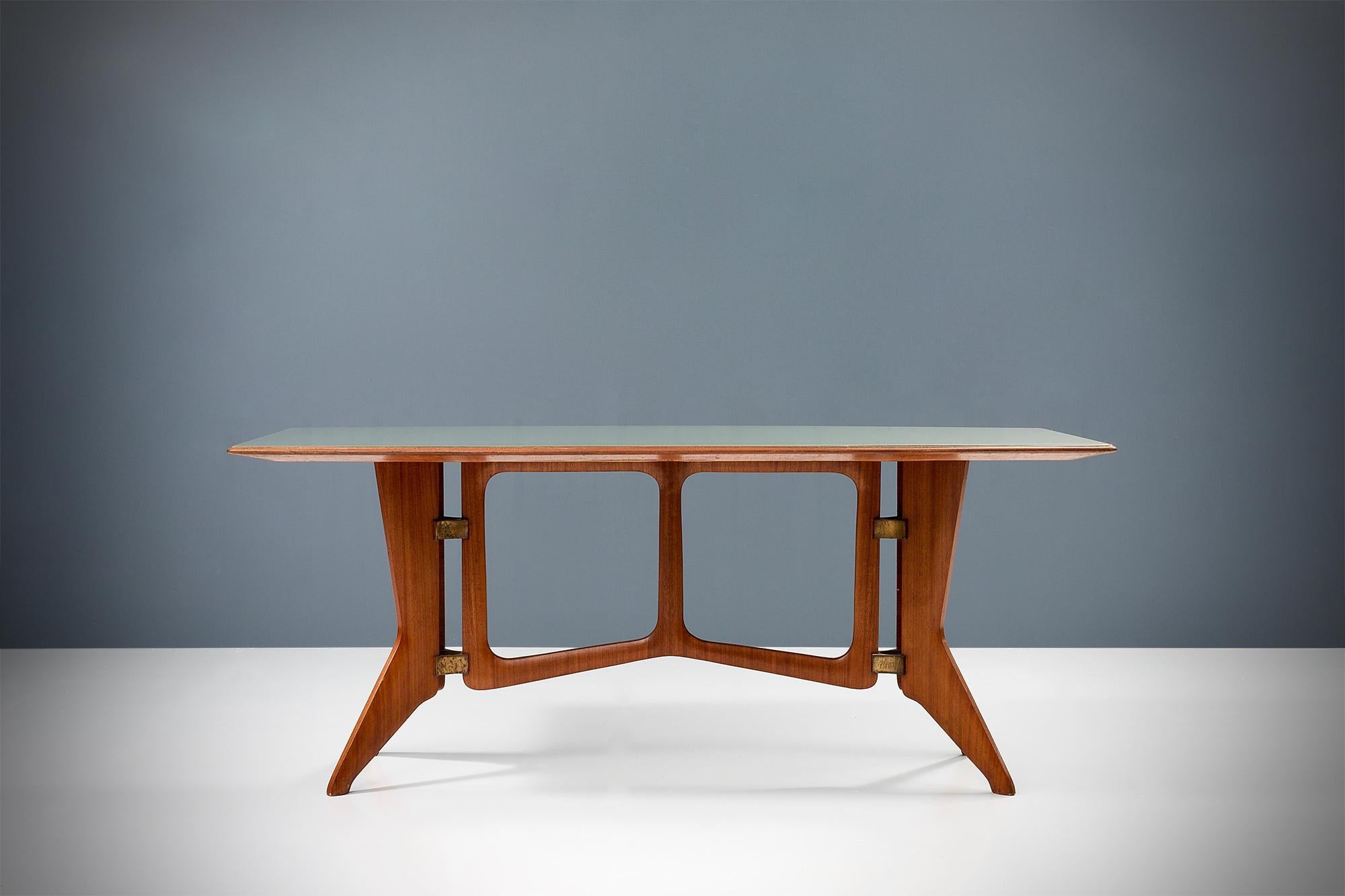 Sculptural Italian dining table by Ariberto Colombo with a teak frame that has aged beautifully over time. The frame is held together by curved triangular brass joints making the table quite sturdy but elegant at the same time. The shapes of this