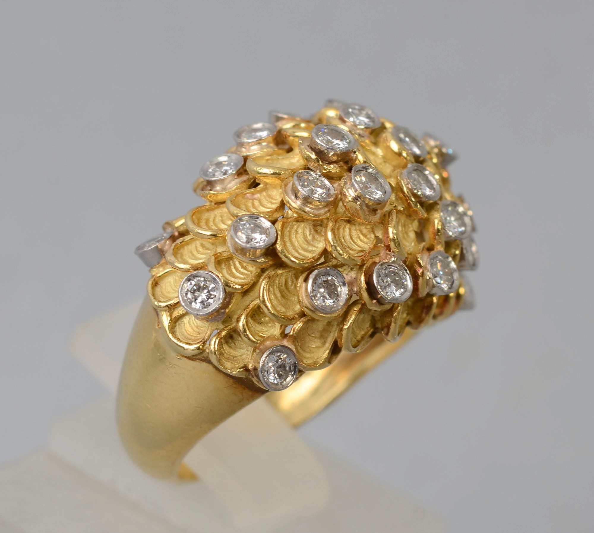 Unusual domed 18 karat gold cocktail ring comprised of textured half circles and diamonds. The ring has 27 European cut diamonds with a total weight of approximately one carat. There is a partial maker's mark that is not legible. The ring is size 8