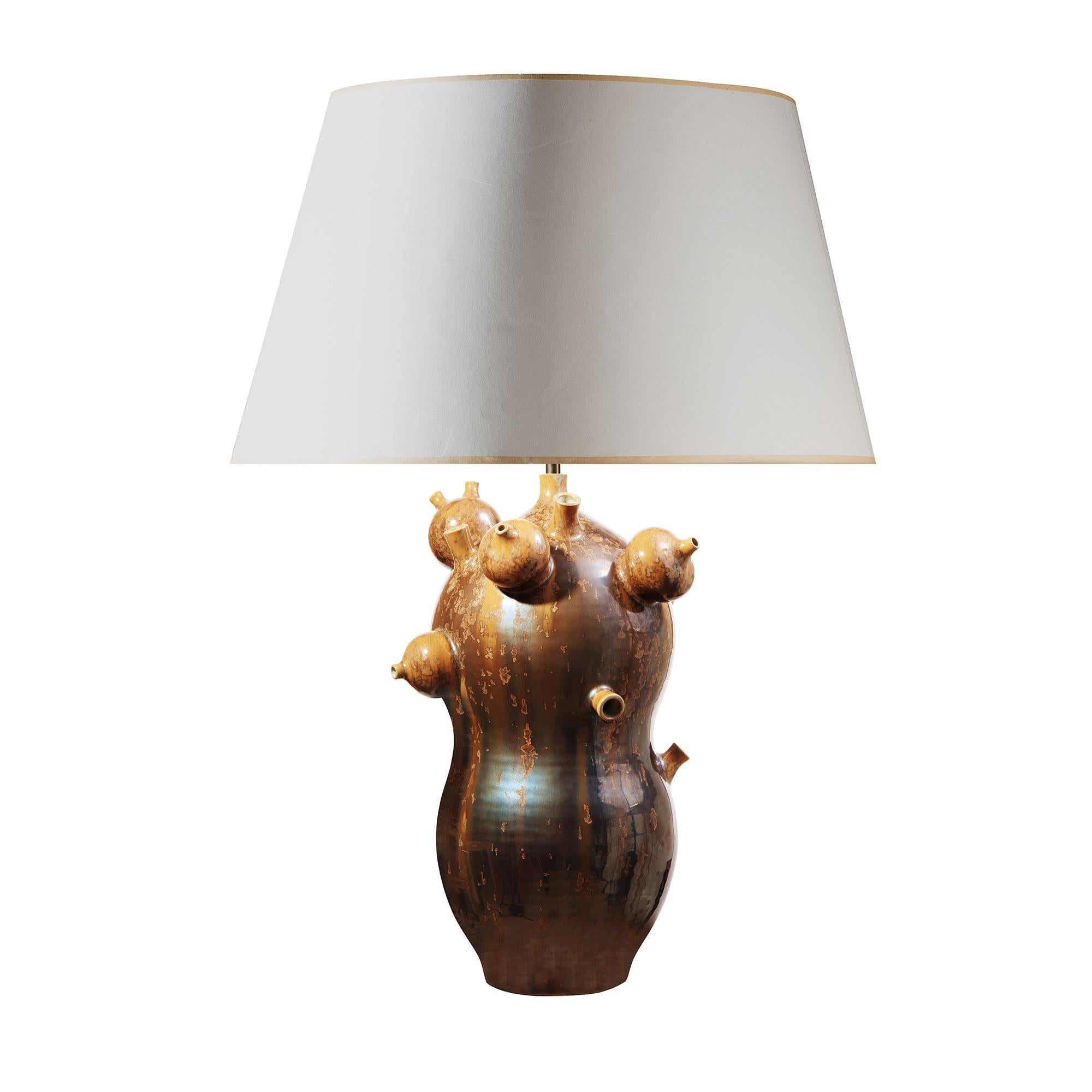 Réinterprétation remarquable du récipient traditionnel chinois à double calebasse, cette lampe sculpturale en porcelaine transforme une forme classique en œuvre d'art contemporaine. Mis en pot de manière experte et richement expressif, le corps se