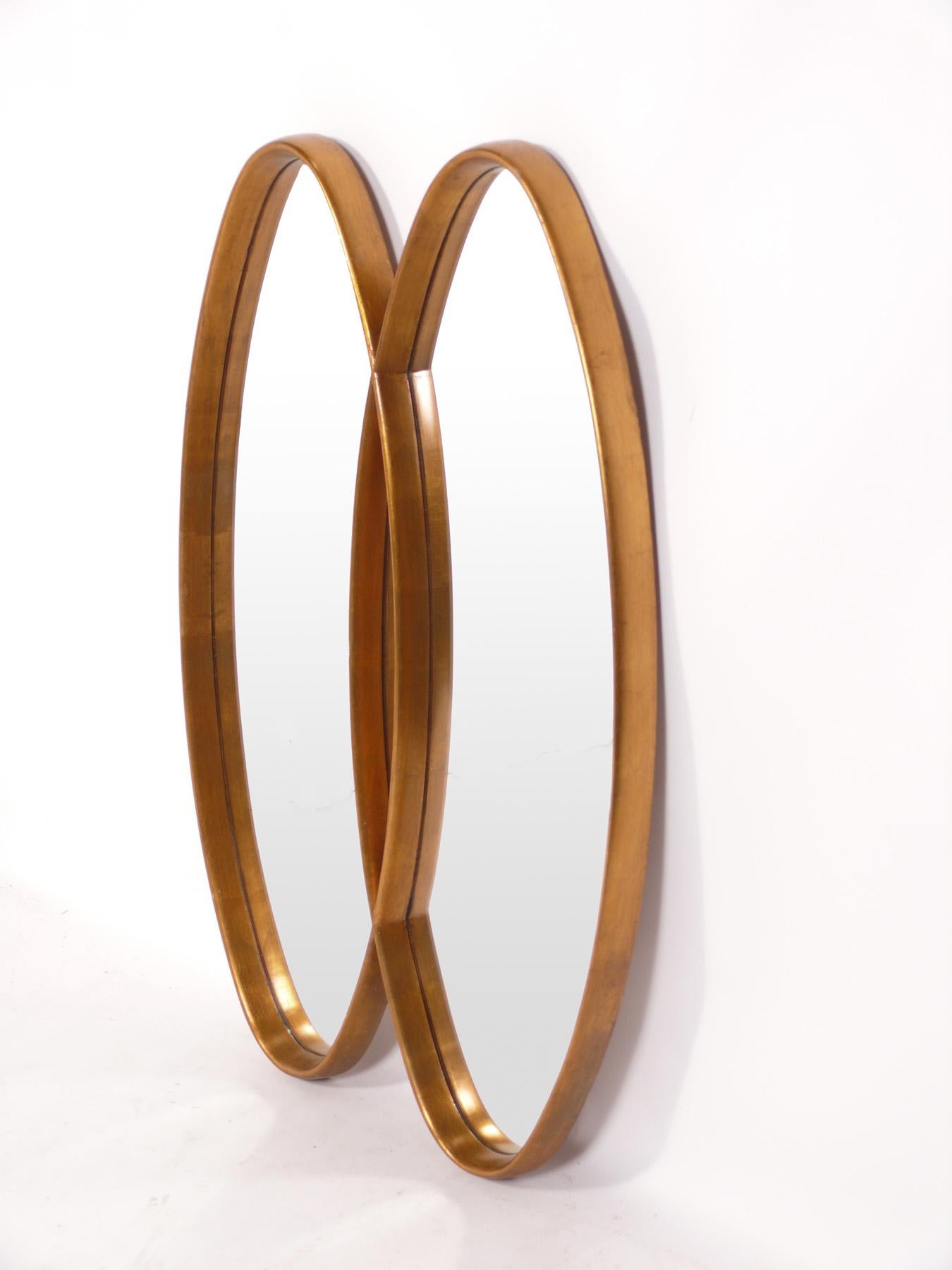 Miroir sculpté double ovale doré, américain, vers les années 1960. Ce miroir a une forme sculpturale et s'intègre parfaitement dans un large éventail d'intérieurs, des plus traditionnels aux plus modernes.