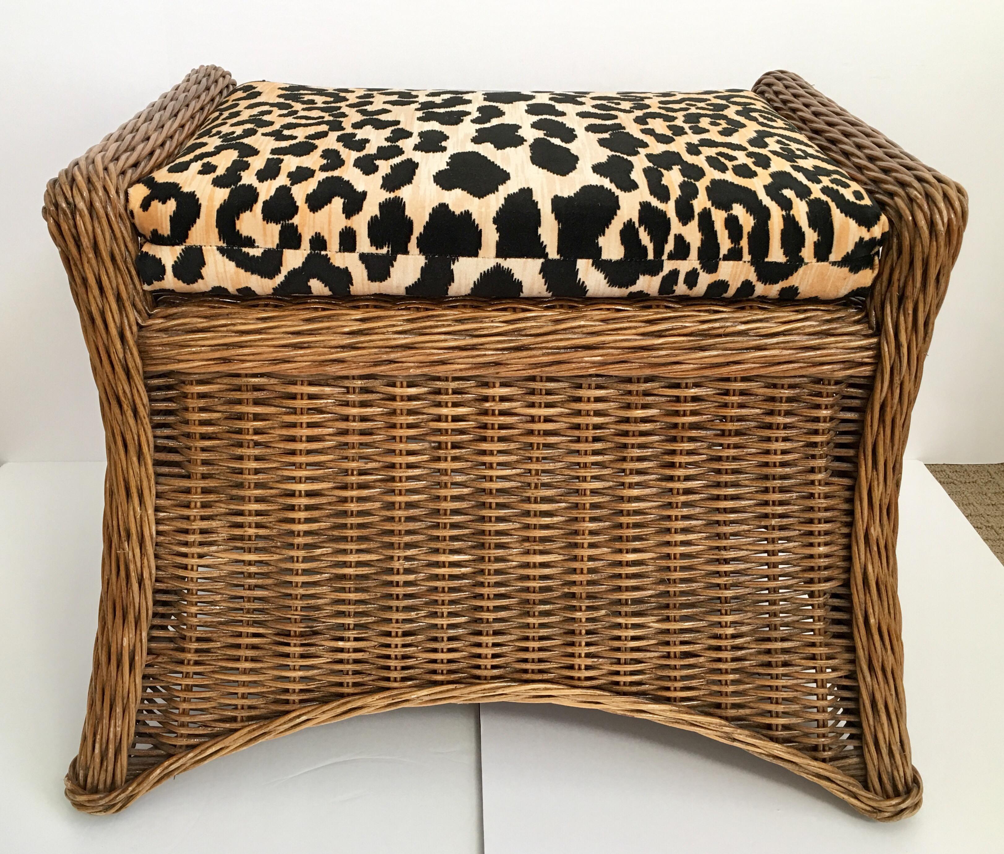 Sculptural woven rattan wicker bench with new custom leopard cheetah print cotton velvet seat cushion. This vintage stool features a curved base with open side handles. Bamboo framing makes this ottoman very sturdy. A versatile accent seat or vanity