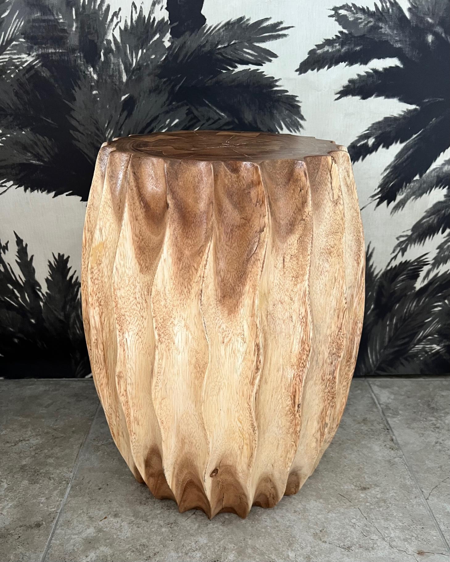 Organic Modern sculptural side table with fluted design. This versatile piece can also be used as a stool or a pedestal. Comprised of reclaimed suar wood, the drum table features hand carved fluted sides with wave formation. Each table is uniquely