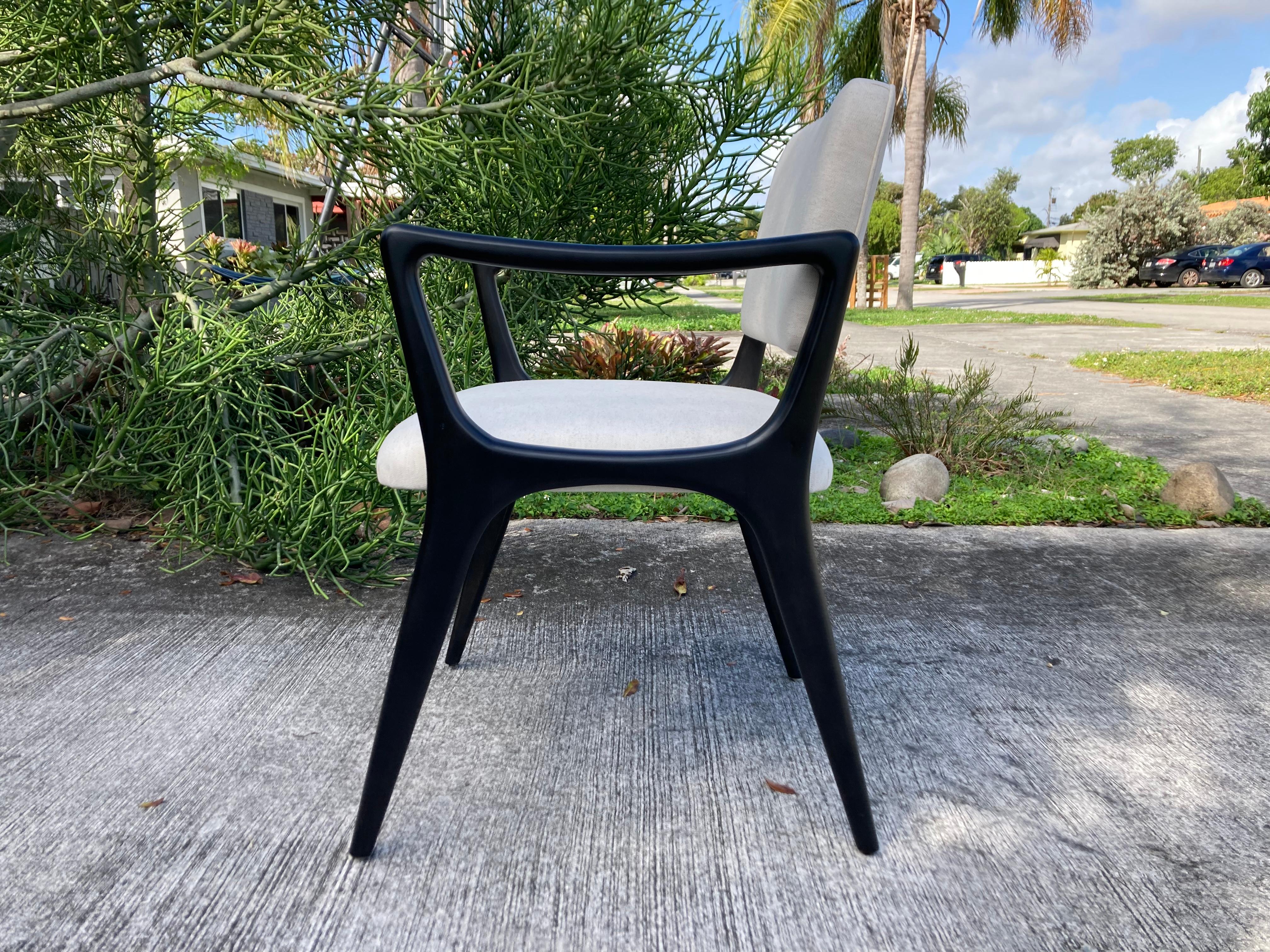Sculptural armchair in the style of Gio Ponti. Solid ebonized maple frames with a satin finish, oatmeal color fabric backs and seats. 
Measure: Arm height is 25.25”.
 More chairs available.