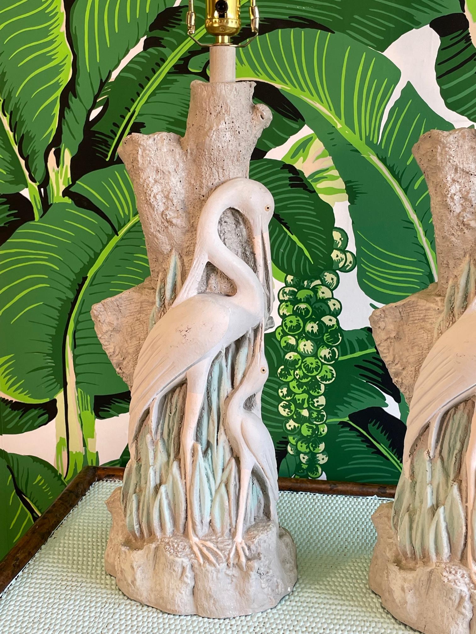 Pair of sculptural table lamps feature a mother and baby egret standing in front of a tree. Good condition with imperfections consistent with age, see photos for condition details. 
    