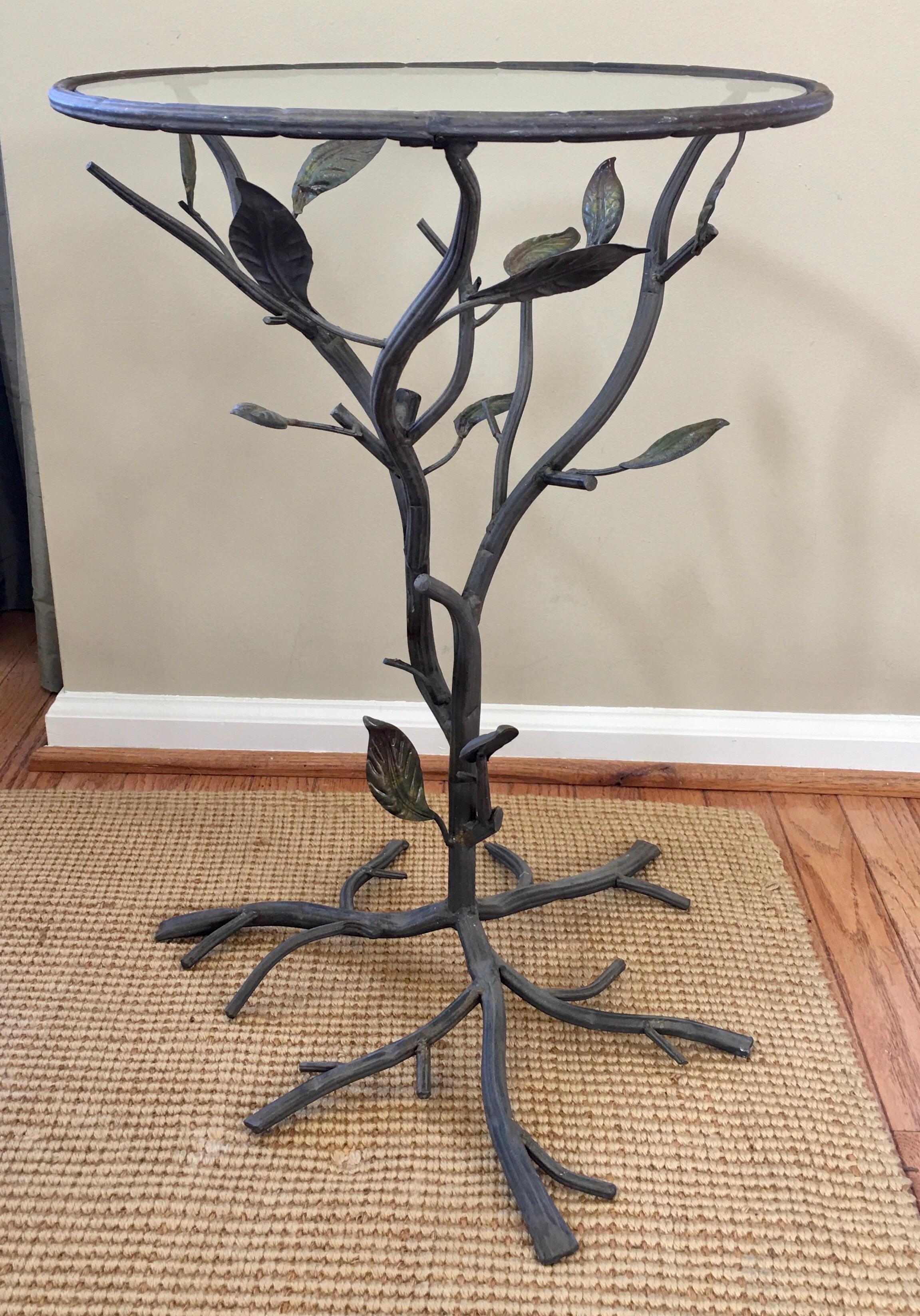 Sculptural faux bois metal and glass side or end table. This round accent table features a faux wood bronze tone metal branch and leaf design with a removable clear glass insert.