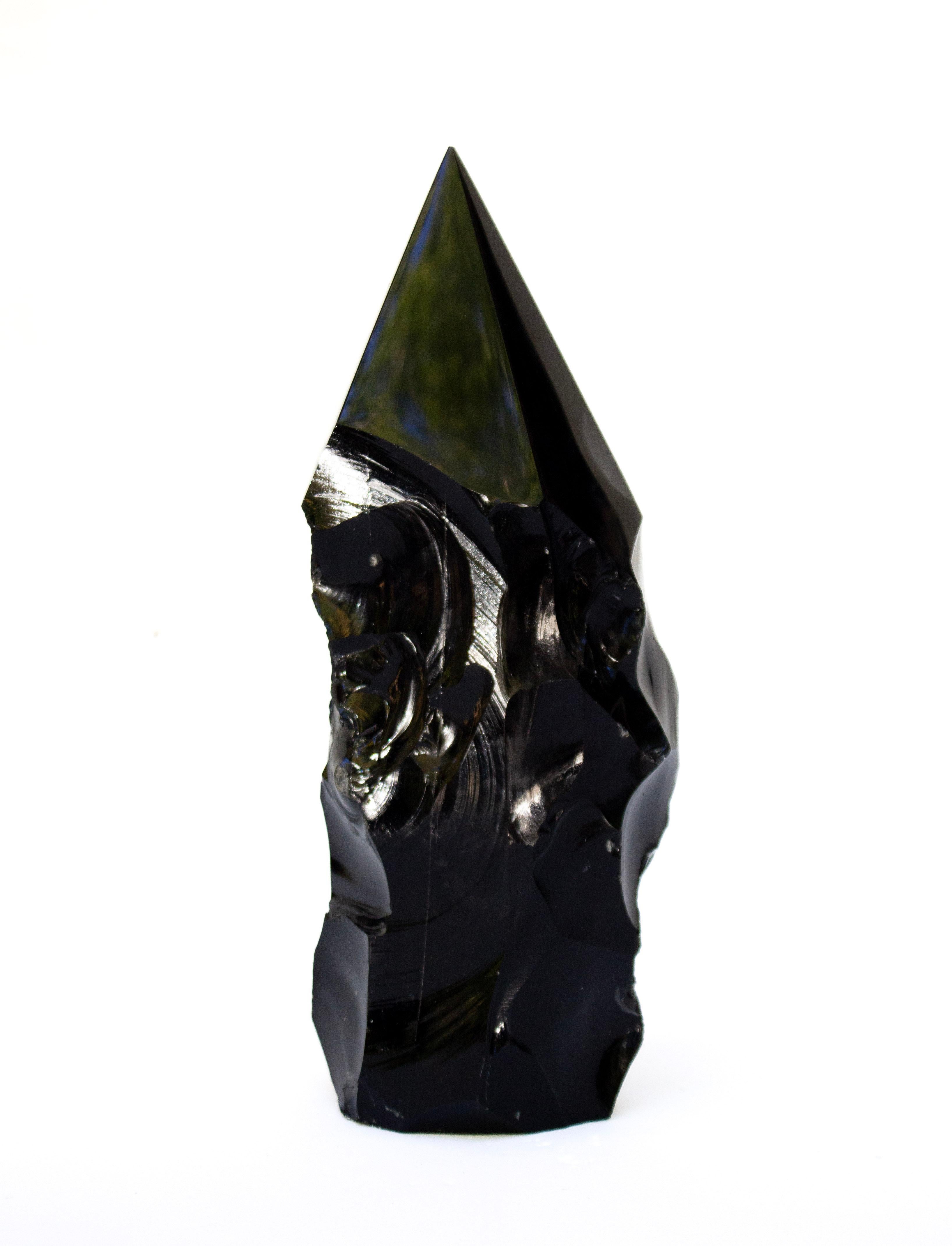 Pointe sculpturale en obsidienne noire avec des indentations de formation naturelle. La pointe a été taillée et polie jusqu'à l'achèvement, mais certaines parties de cette pièce ont été laissées dans leur forme organique pour ressembler à une
