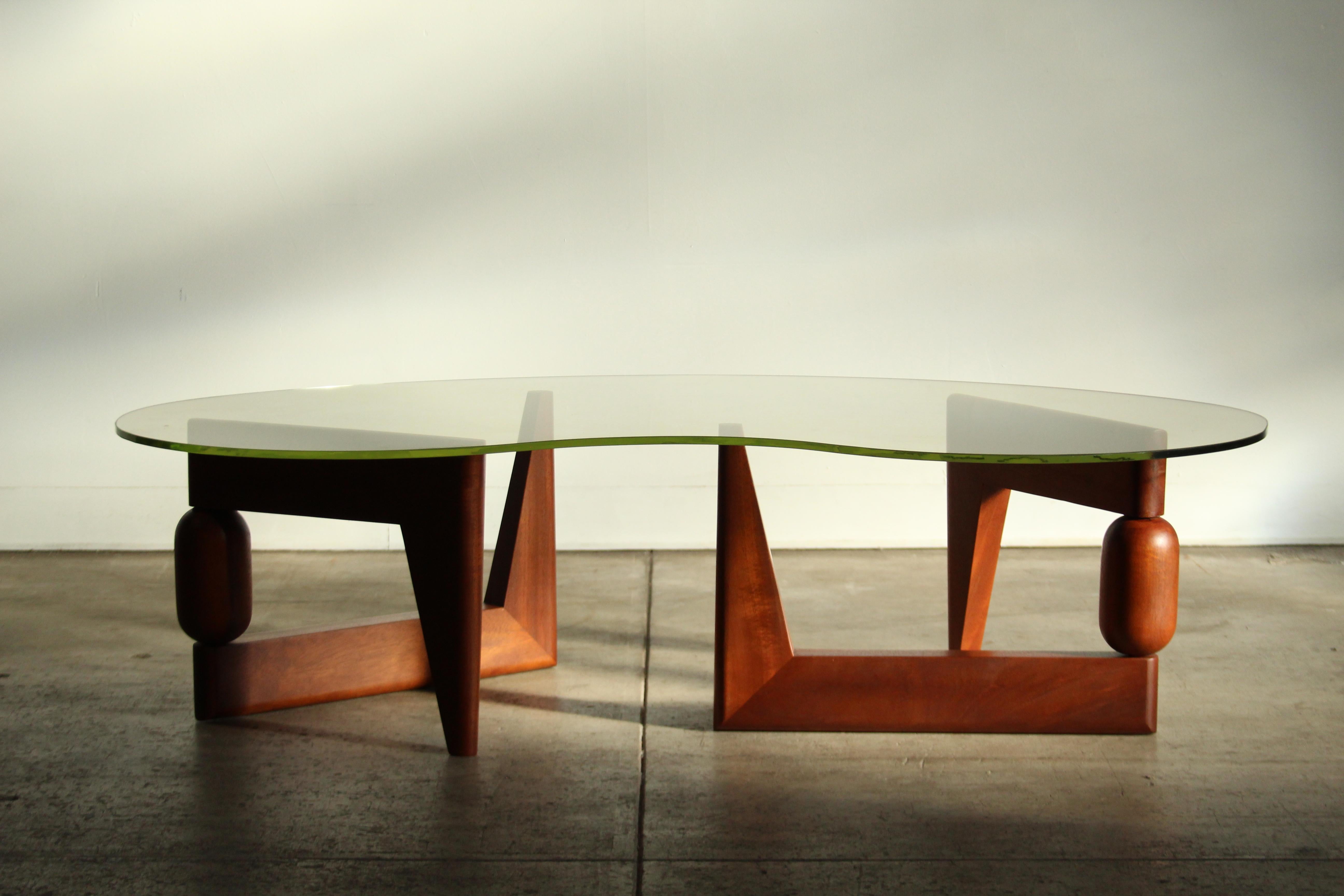 Une étonnante table basse sculpturale de forme libre avec des bases articulées en acajou massif et un verre original vert uranium. Probablement fabriquée dans les années 1970 par un designer inconnu. Les bases ont été restaurées avec amour et sont