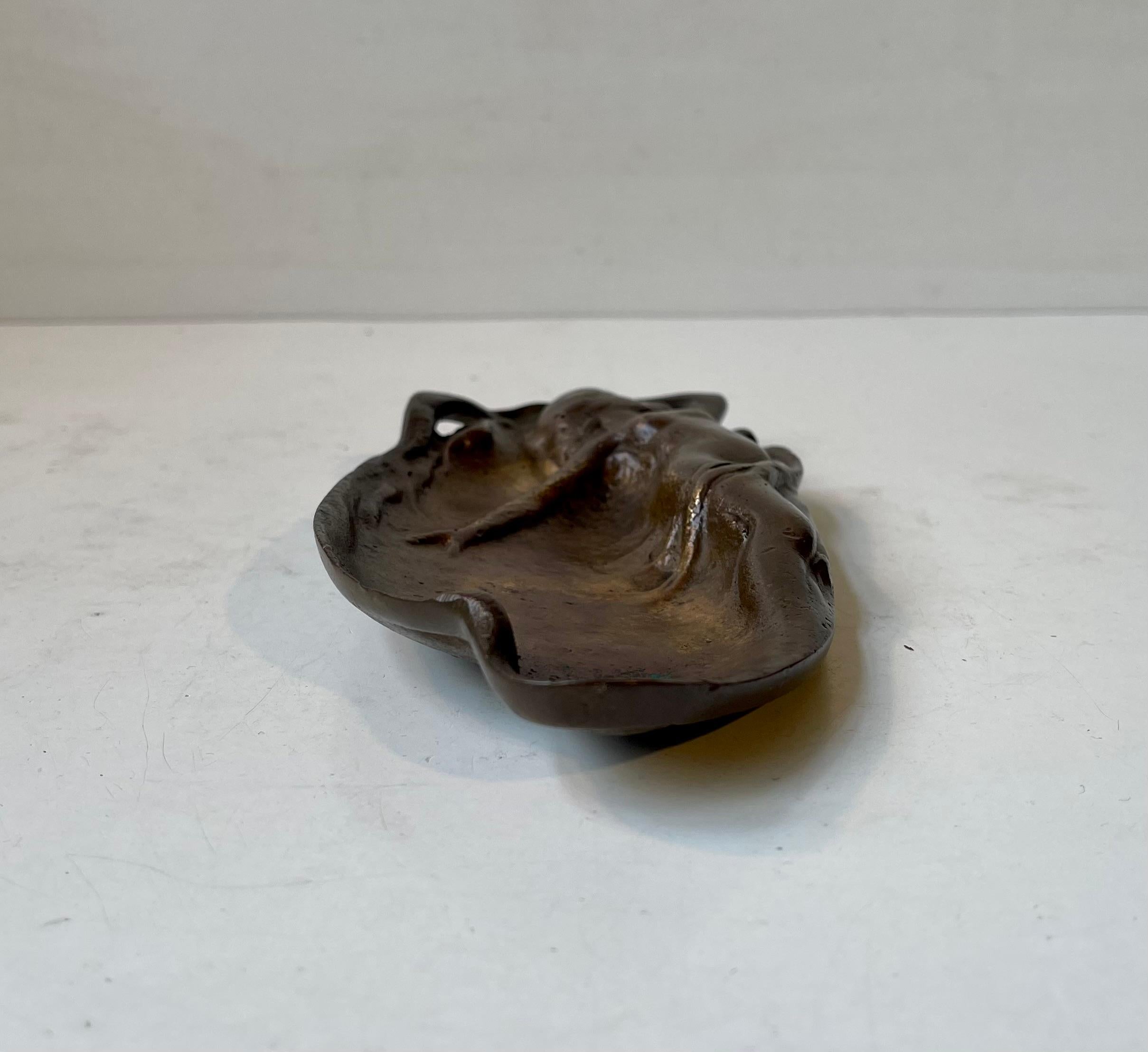Plat décoratif ou cendrier en bronze moulé représentant une jeune sirène nue aux cheveux longs. Patine/vieillissement intacts. Coulée anonyme en France vers 1910-30. Dimensions : 18,5 x 9 x 2,5 cm.