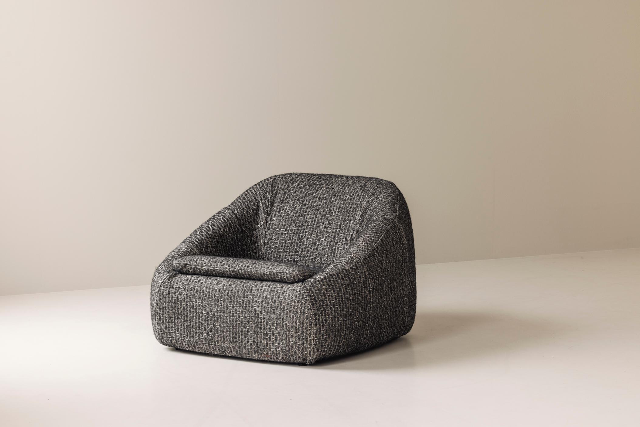 A timeless blend of comfort and modernist elegance, this sculptural lounge chair dates back to the 1960s and has been thoughtfully reupholstered in a refined, textured fabric that enhances its bold, organic silhouette. With its low, inviting profile