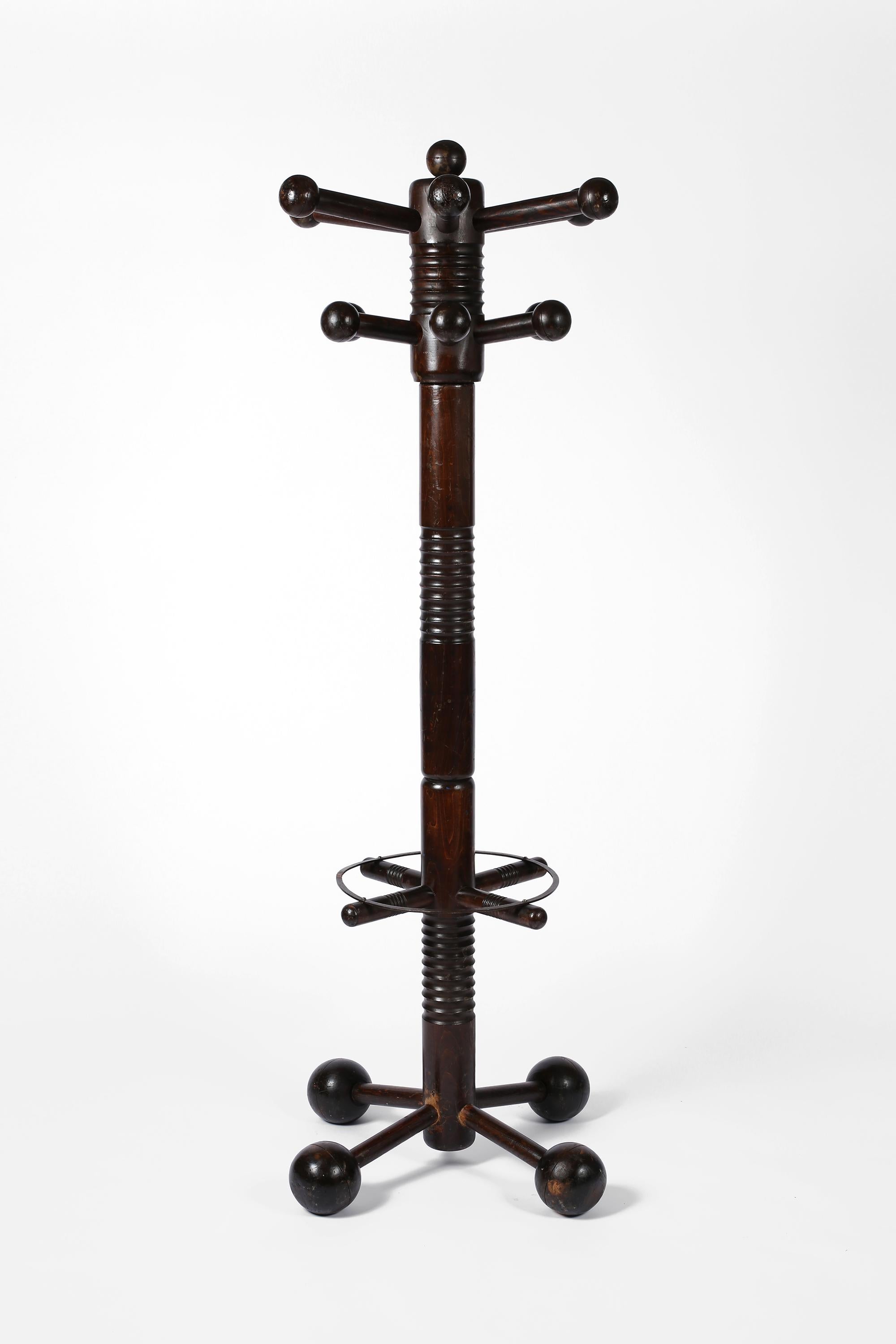 A sculptural, totem-like coat stand by modernist designer Charles Dudouyt. Constructed from dark stained oak, with ring turned detailing to the stem and Dudouyt’s signature boule feet & pegs. The circular forged iron umbrella stand remains intact.