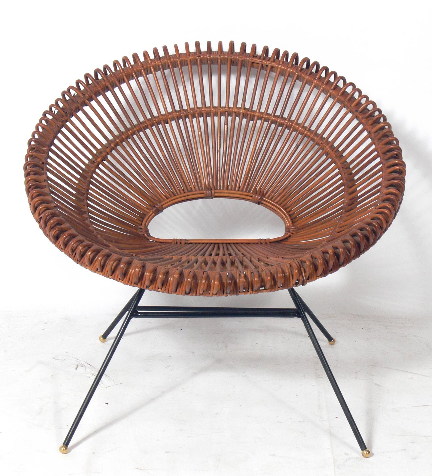 Sculptural French rattan and iron chairs, designed by Dirk Jan Rol and Janine Abraham, France, circa 1950s. These chairs are a near pair, as they have some variations, mainly to the iron bases and slight variations to the size (the one on the left