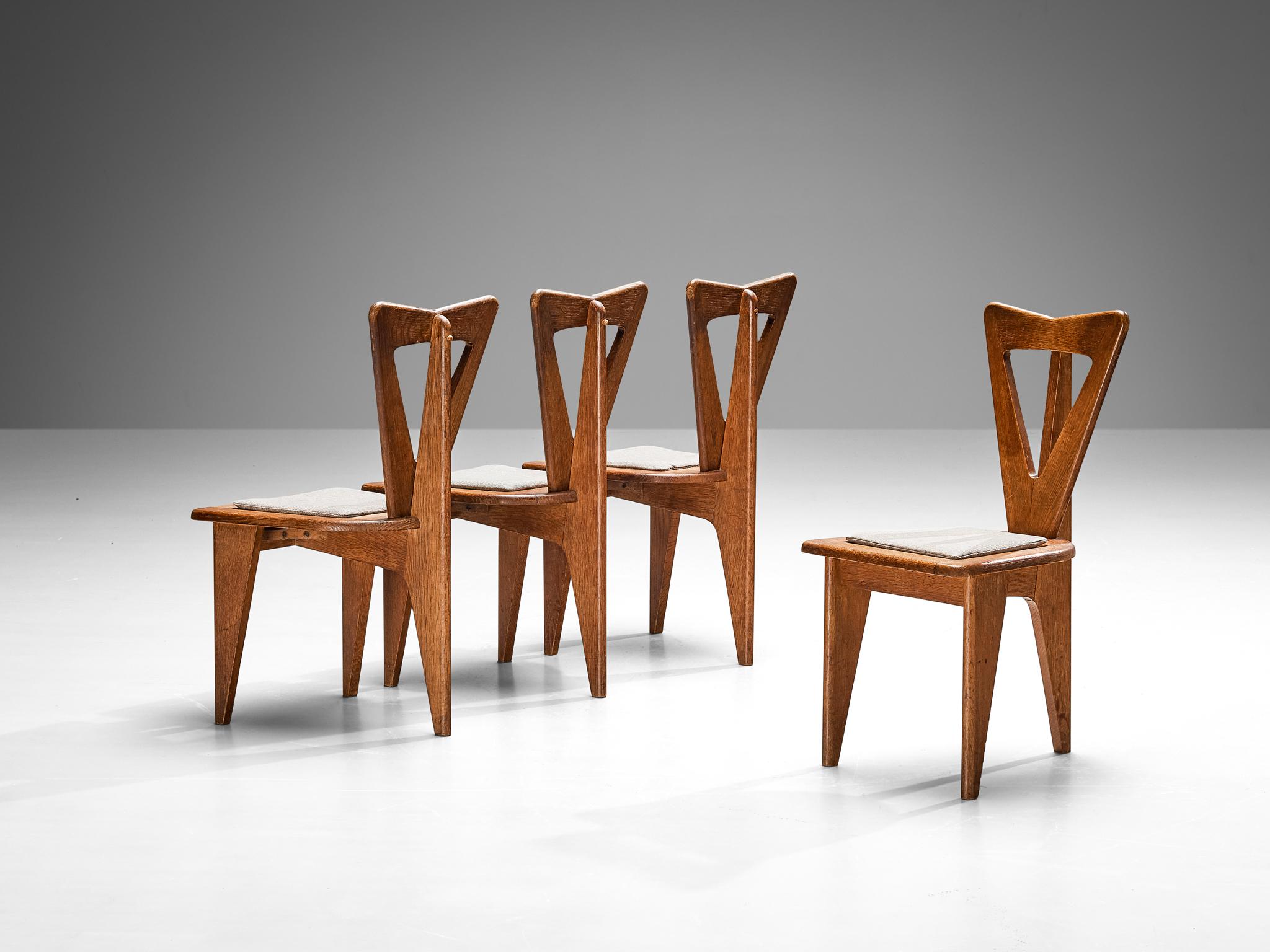 Set of four dining chairs, oak, fabric, France, 1950s

Captivating in both form and material usage, these French dining chairs resonate with the design principles that were prevalent during the 1950s and 1960s. These chairs share a design ethos akin