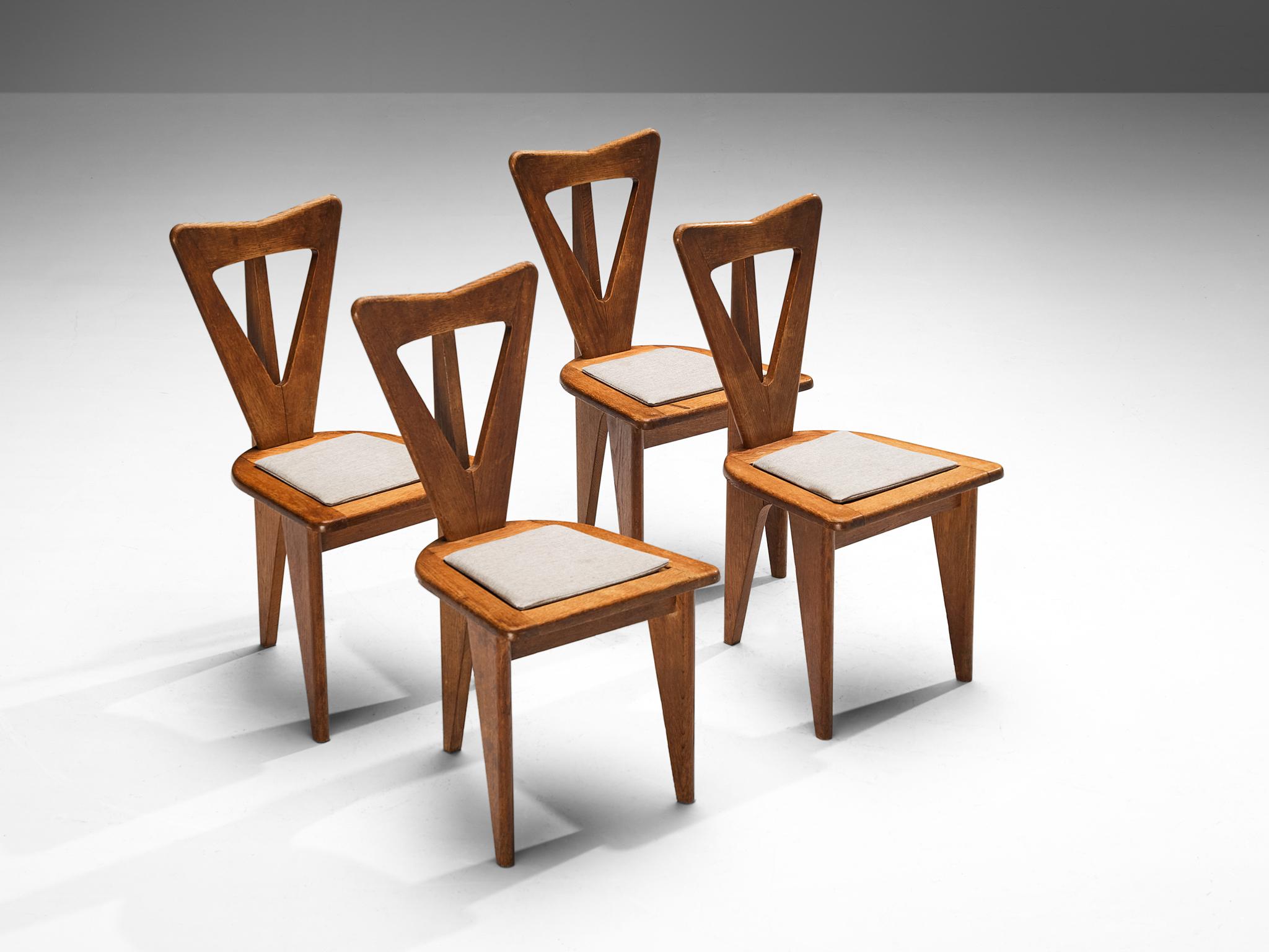 Milieu du XXe siècle Ensemble sculptural français de quatre chaises de salle à manger en chêne massif 
