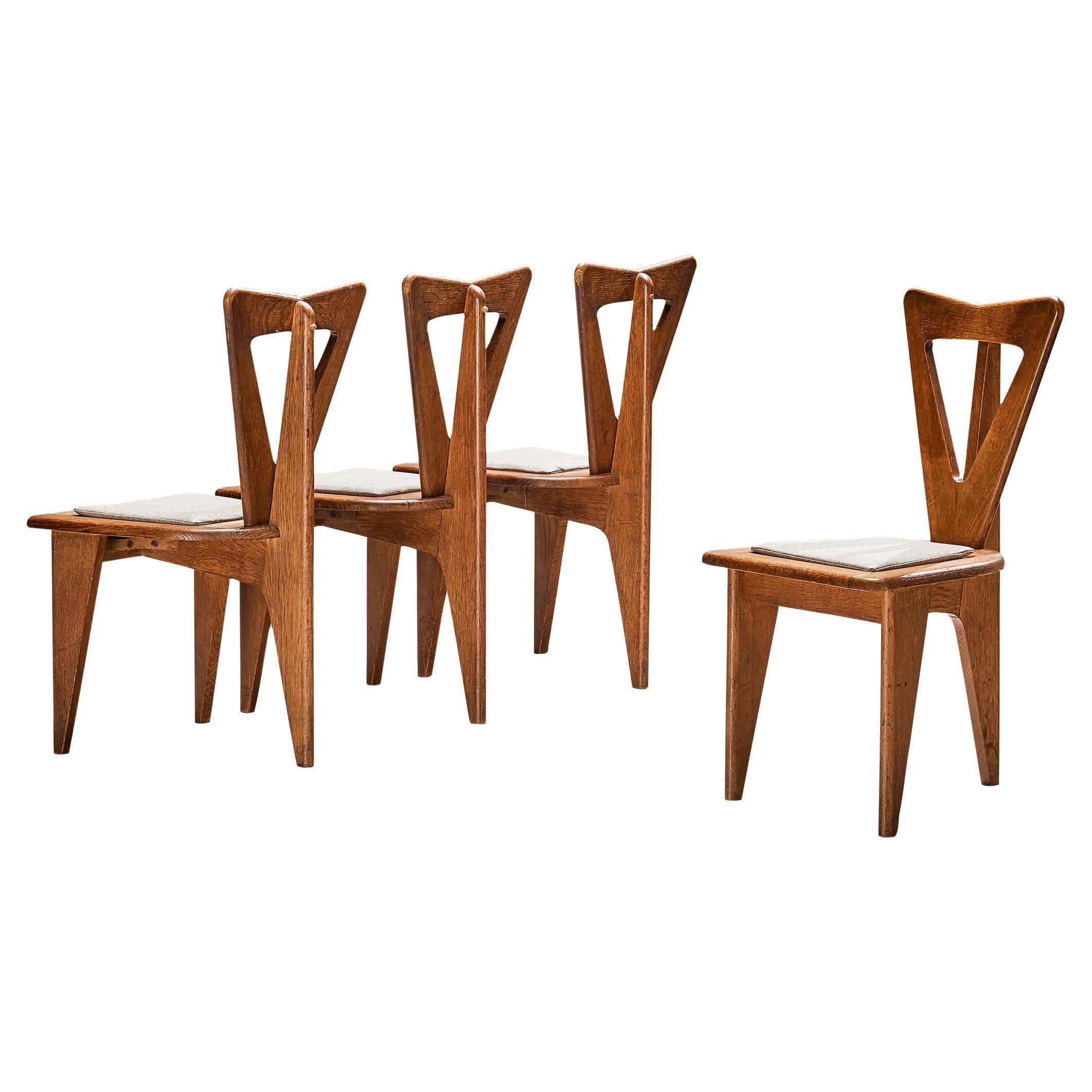 Ensemble sculptural français de quatre chaises de salle à manger en chêne massif 