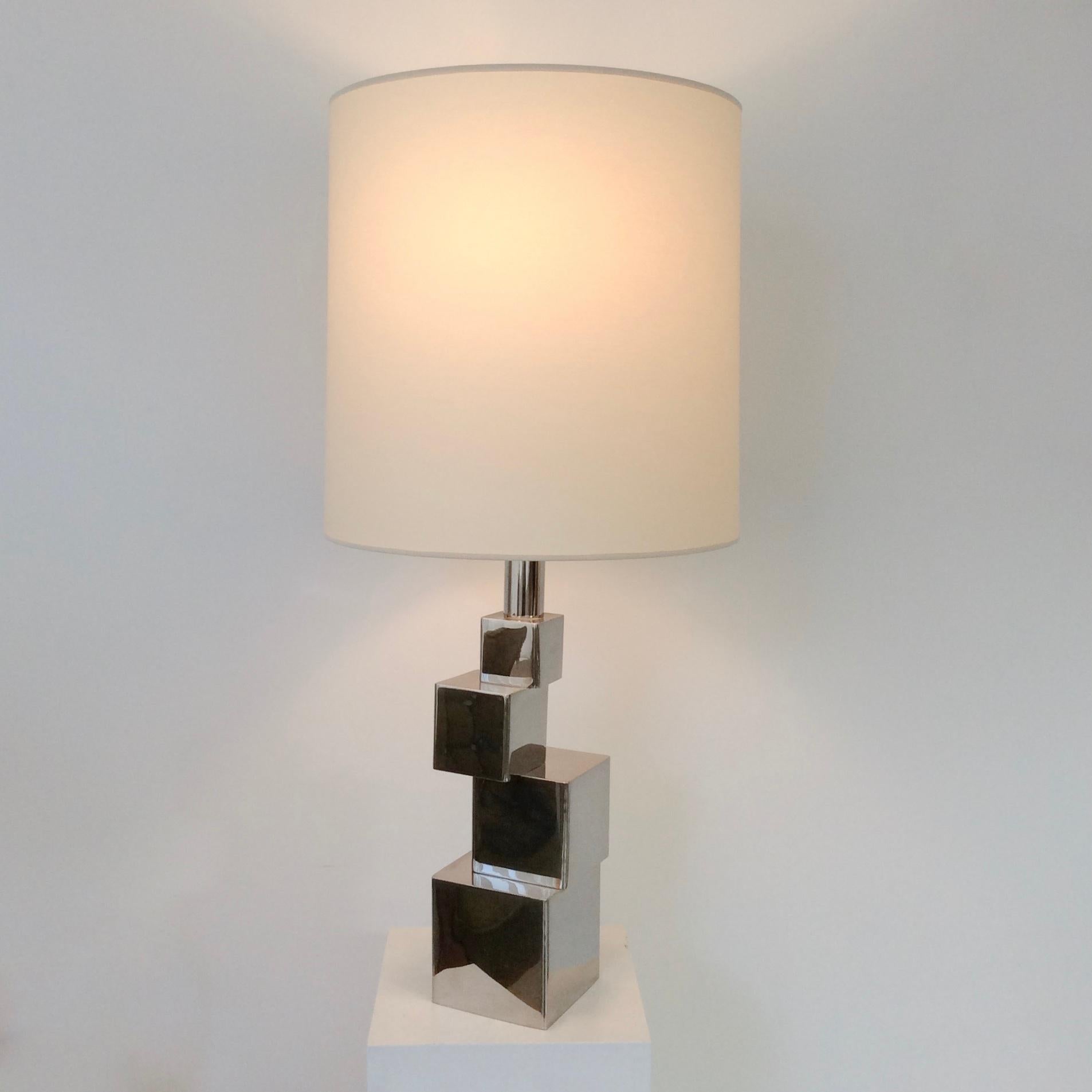 Sculptural geometric table lamp, circa 1970, France.
Chromed metal, new ivory fabric shade.
Dimensions: 82 cm H, diameter of the shade: 38 cm, base: 12 x 12 cm.
Good condition.
 