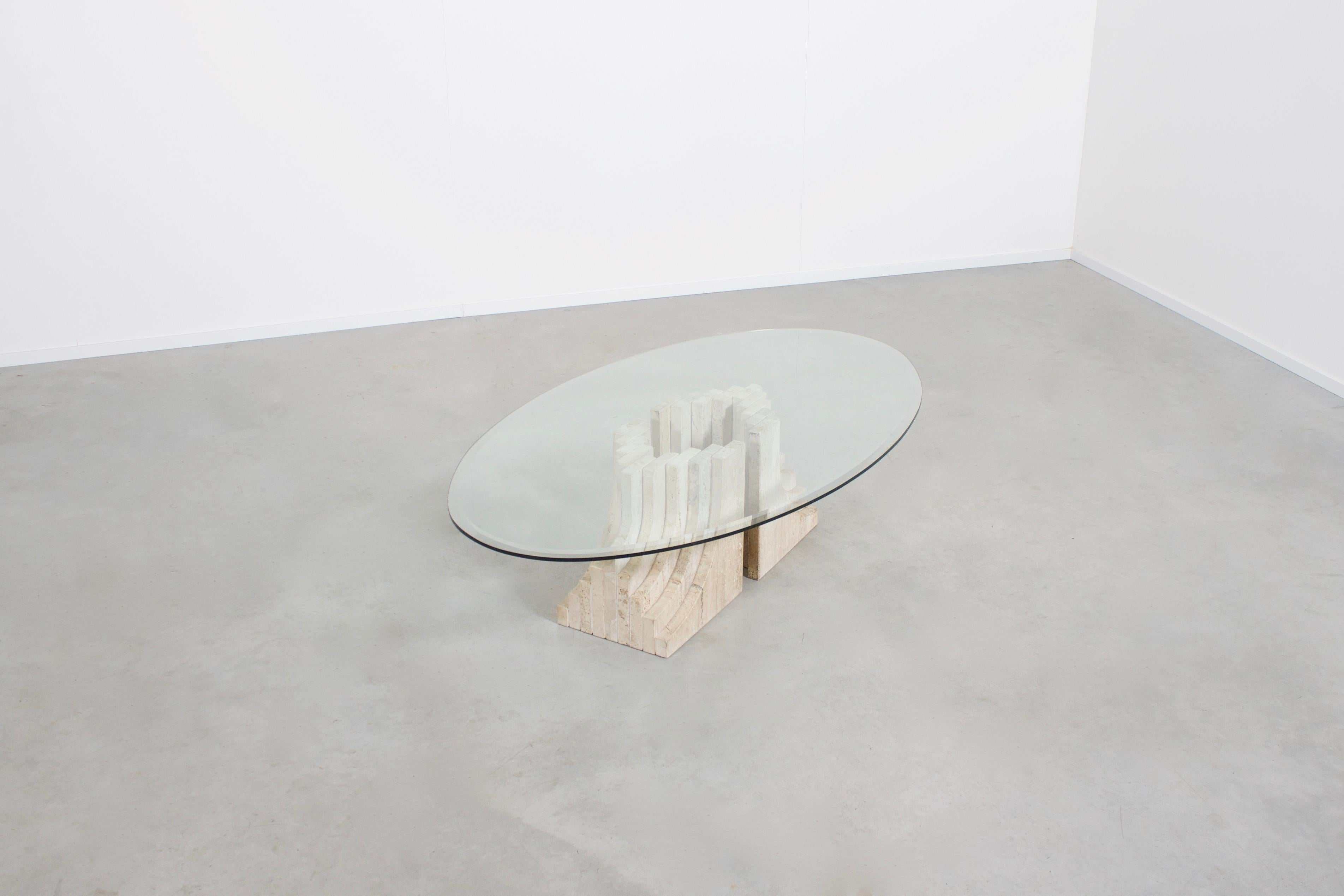 Sculptural coffee table in very good condition in the style of Tobia Scarpa

The table consists of two multi-layered travertine bases and an oval glass top.

The bases are made of 9 layers of stacked solid travertine slabs.

References: Mangiarotti,