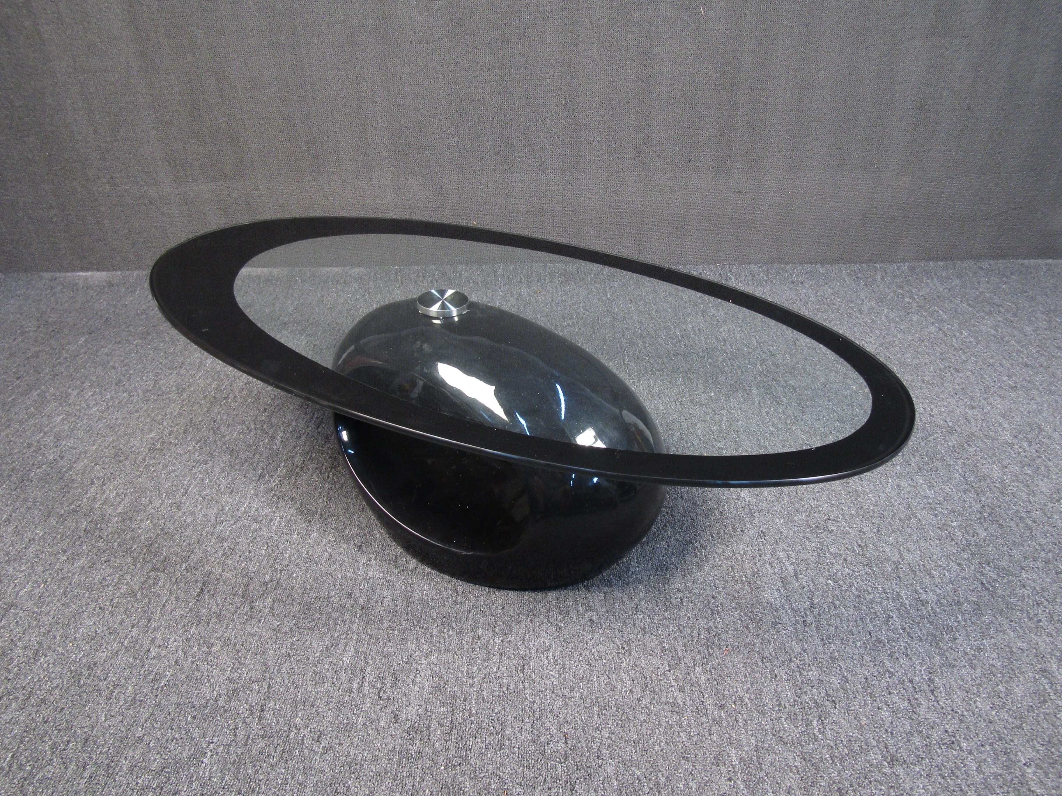 A highly unusual vintage coffee table that is sure to wow with its geometric rounded forms. A transparent glass top is accented by the tabletop's glossy black frame and base. Please confirm item location with seller (NY or NJ).