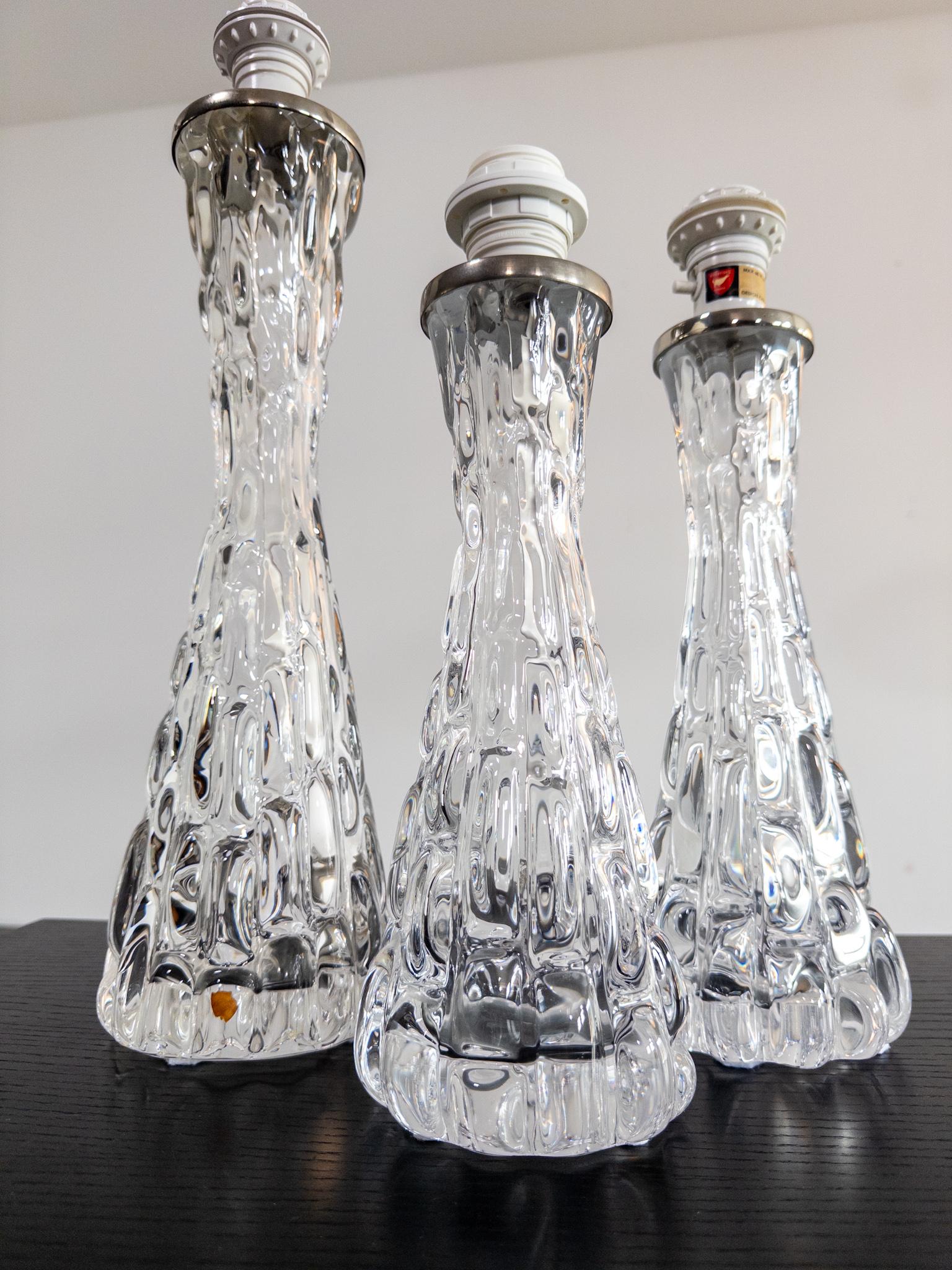 Un ensemble saisissant de trois lampes de table en verre texturé conçues par Carl Fagerlund pour Orrefors, Suède, dans les années 1960. Chaque lampe est dotée d'un verre bulle épais, soufflé à la main, d'une texture sculpturale et organique qui