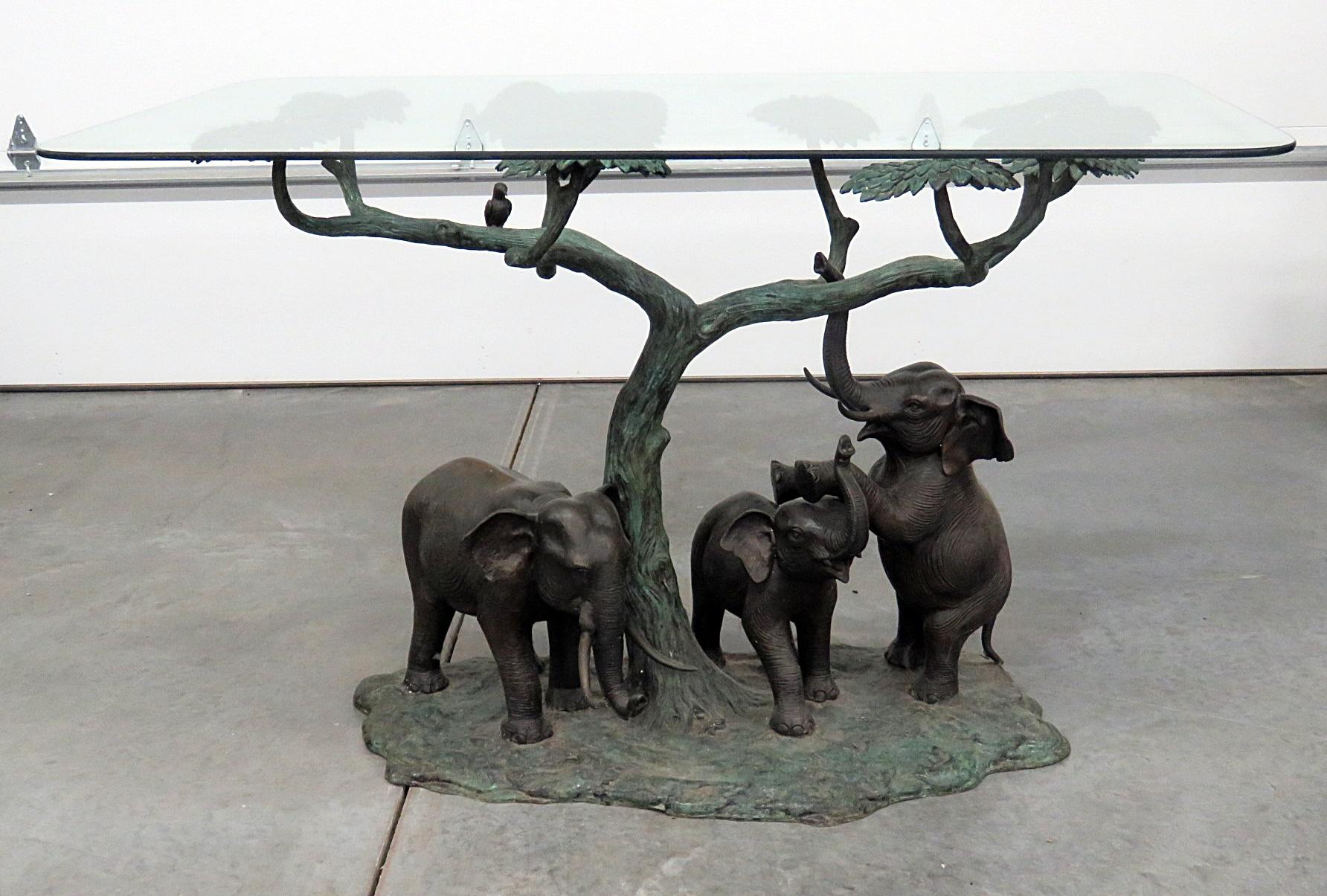 Sculptural glass top center table with an elephant scene base.