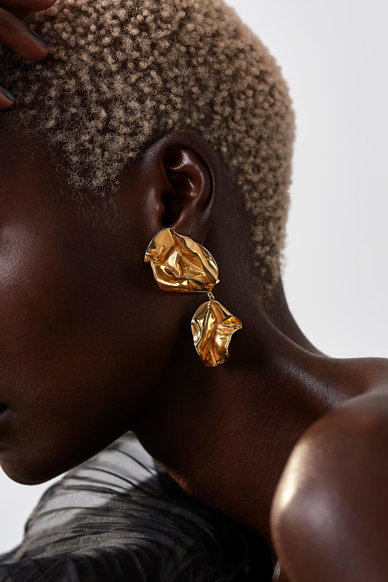 The Fold Earrings are sculptural folded earrings that have been molded by hand. Their intricate folds are highlighted by the high-polished Mirror Finish. Wear them day or night with your hair tucked back to let them shine. 18k gold plated brass.