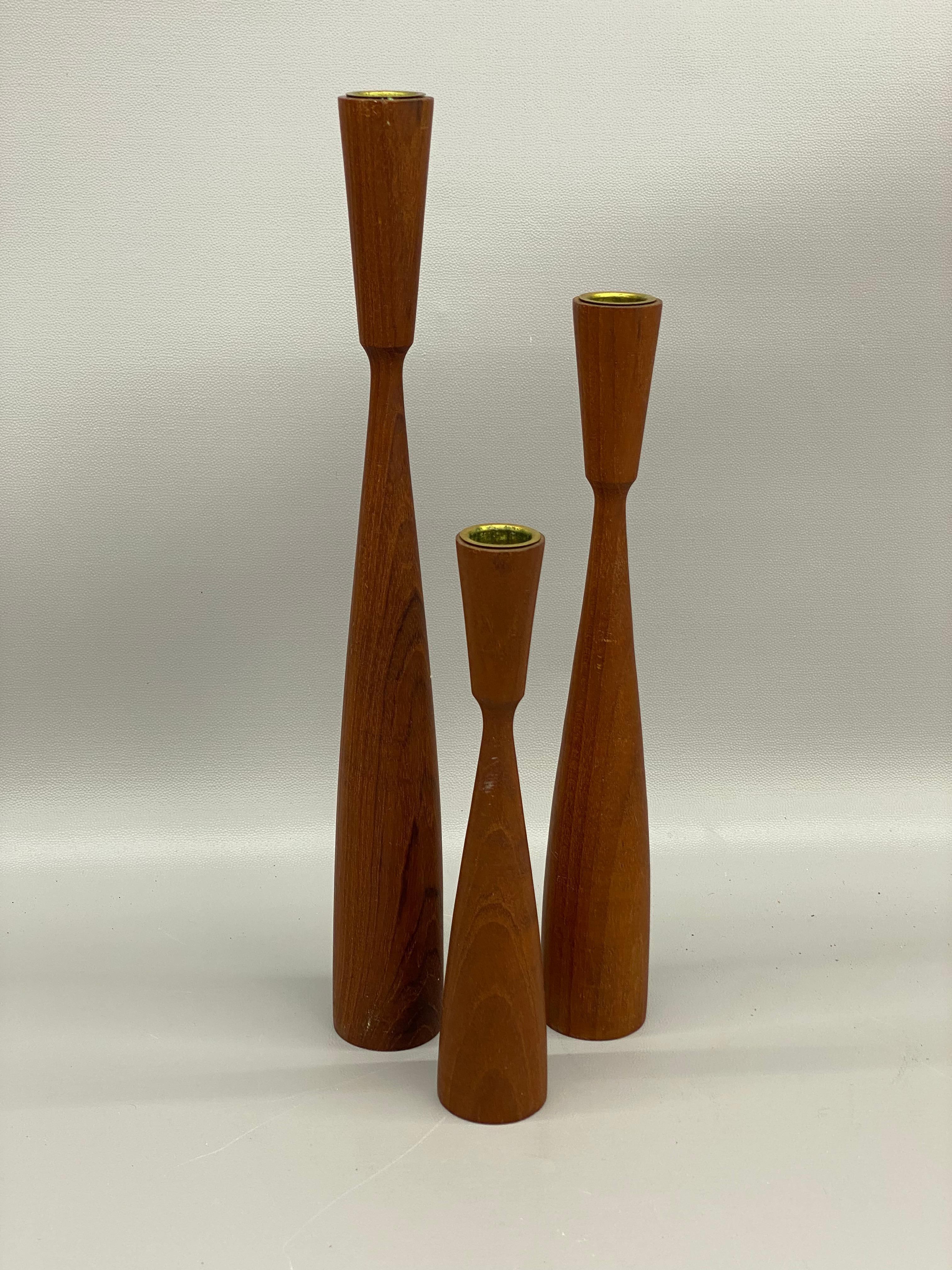 A fine sculptural set of Danish turned teak candlesticks. Ink stamp, Made in Denmark. Top metal insert. Organic Danish design featuring soft lines and quality materials. Each measures approximately 14.75