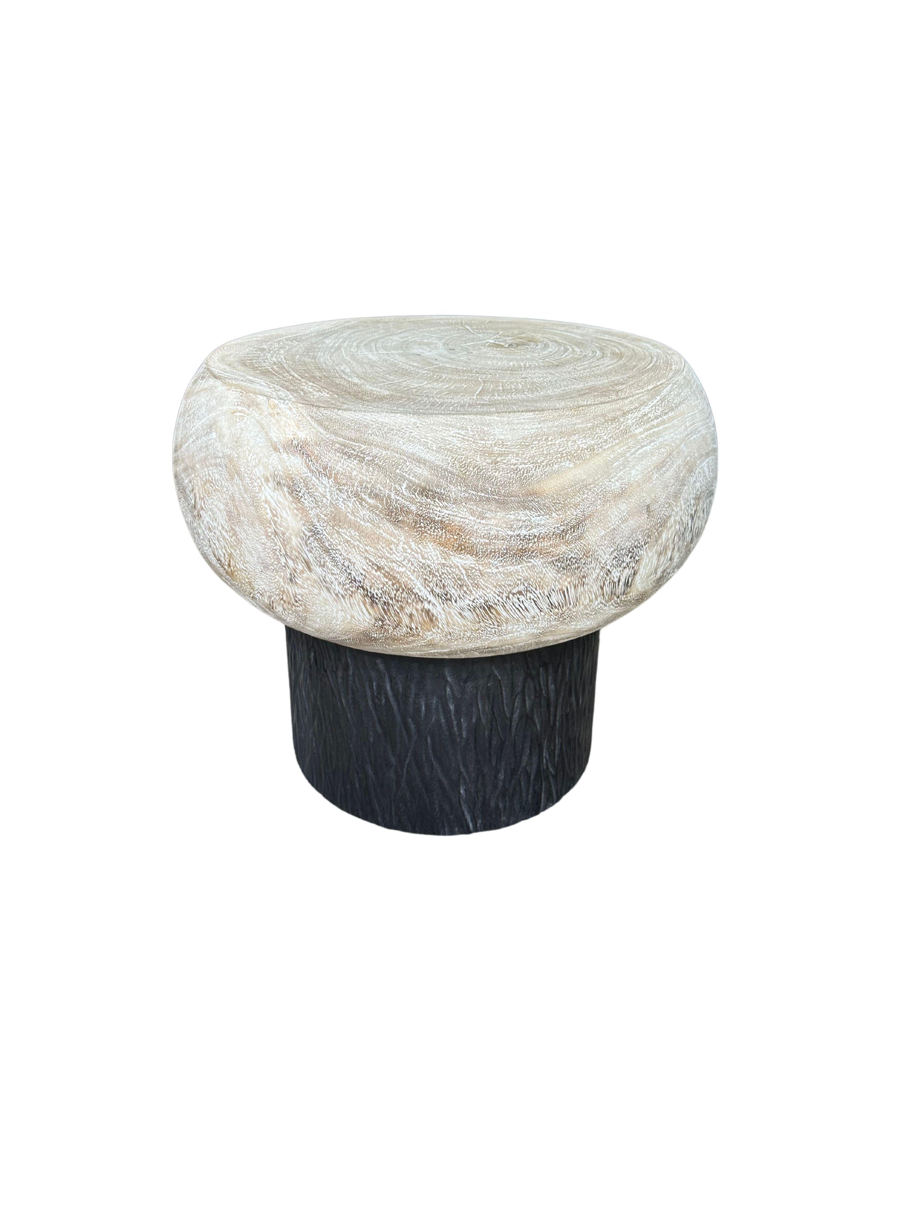 Élevez votre espace de vie avec cette table d'appoint ronde sculpturale en bois de manguier, un mélange saisissant d'art et de beauté naturelle. La table est dotée d'une base méticuleusement sculptée à la main qui présente des détails complexes,