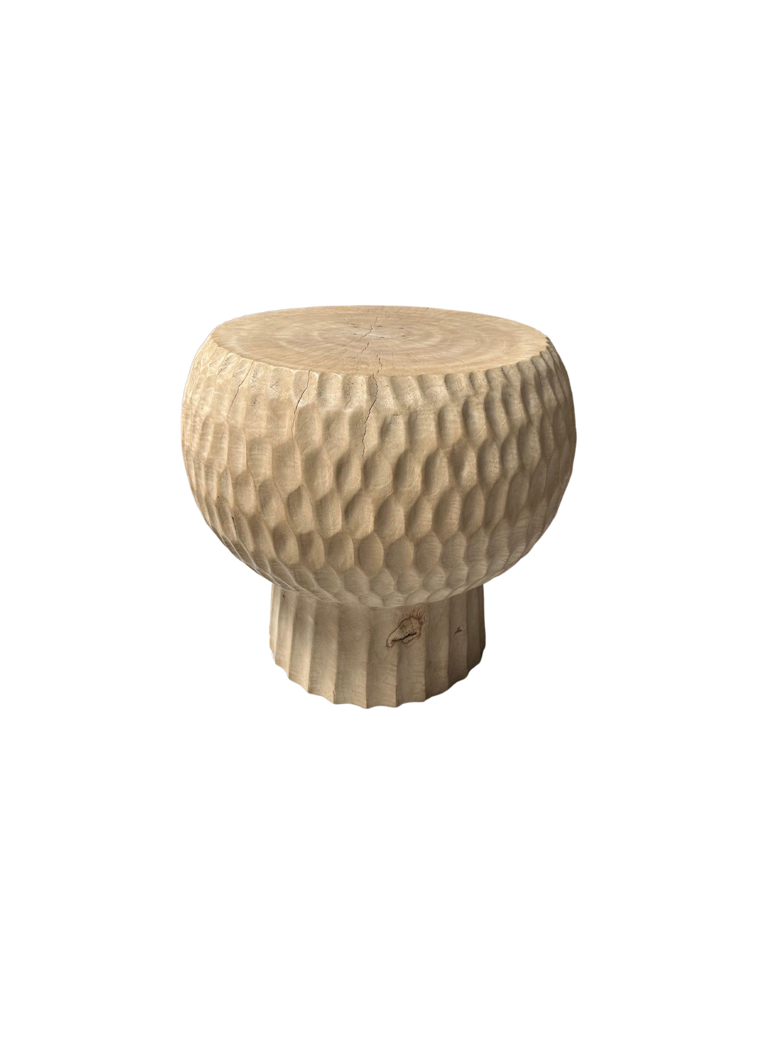 Voici notre exquise table d'appoint ronde, fabriquée de manière experte en bois de manguier. Cette pièce étonnante présente des détails géométriques complexes sculptés à la main sur ses côtés, mettant en valeur l'habileté de l'artisan et ajoutant