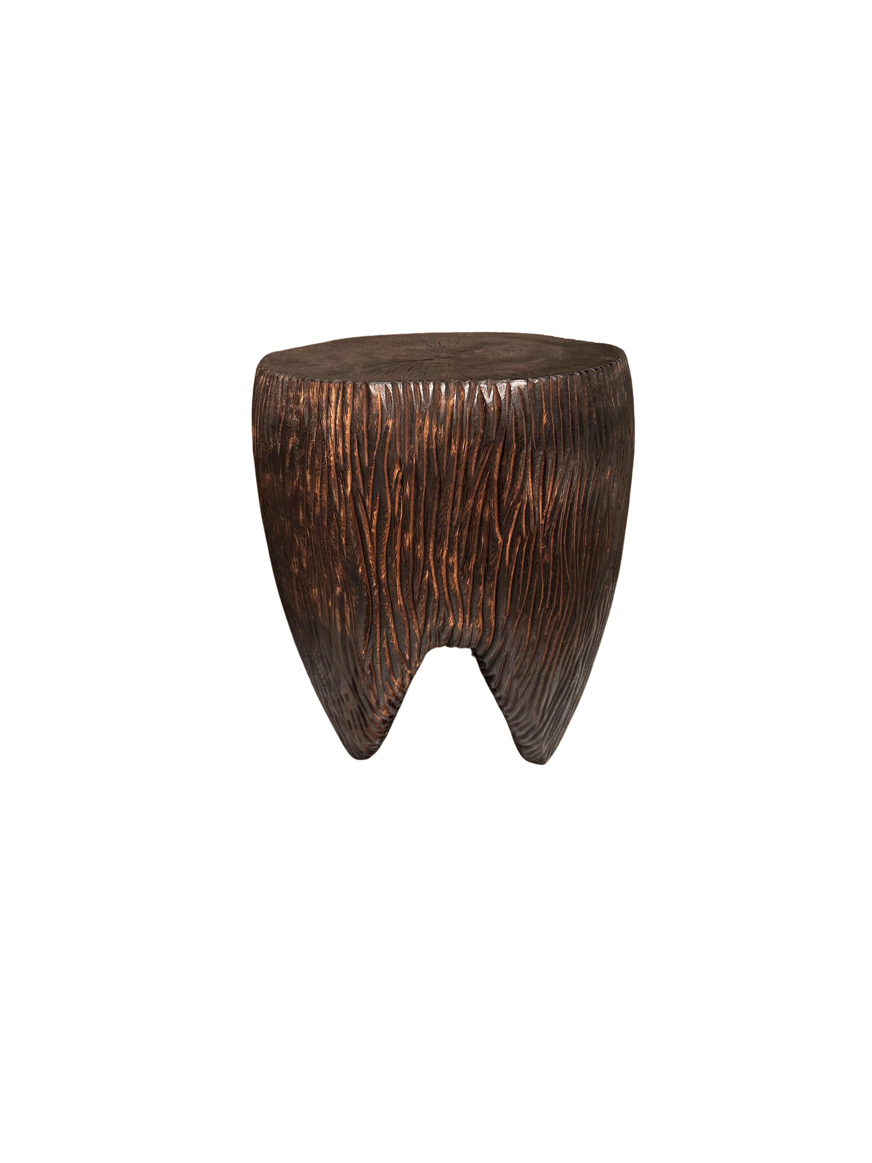 Wir präsentieren einen atemberaubenden skulpturalen Beistelltisch aus Mangoholz, der Kunst und Funktionalität auf wunderbare Weise miteinander verbindet. Dieses exquisite Stück weist kunstvoll geschnitzte Seiten auf, die die natürliche Maserung des