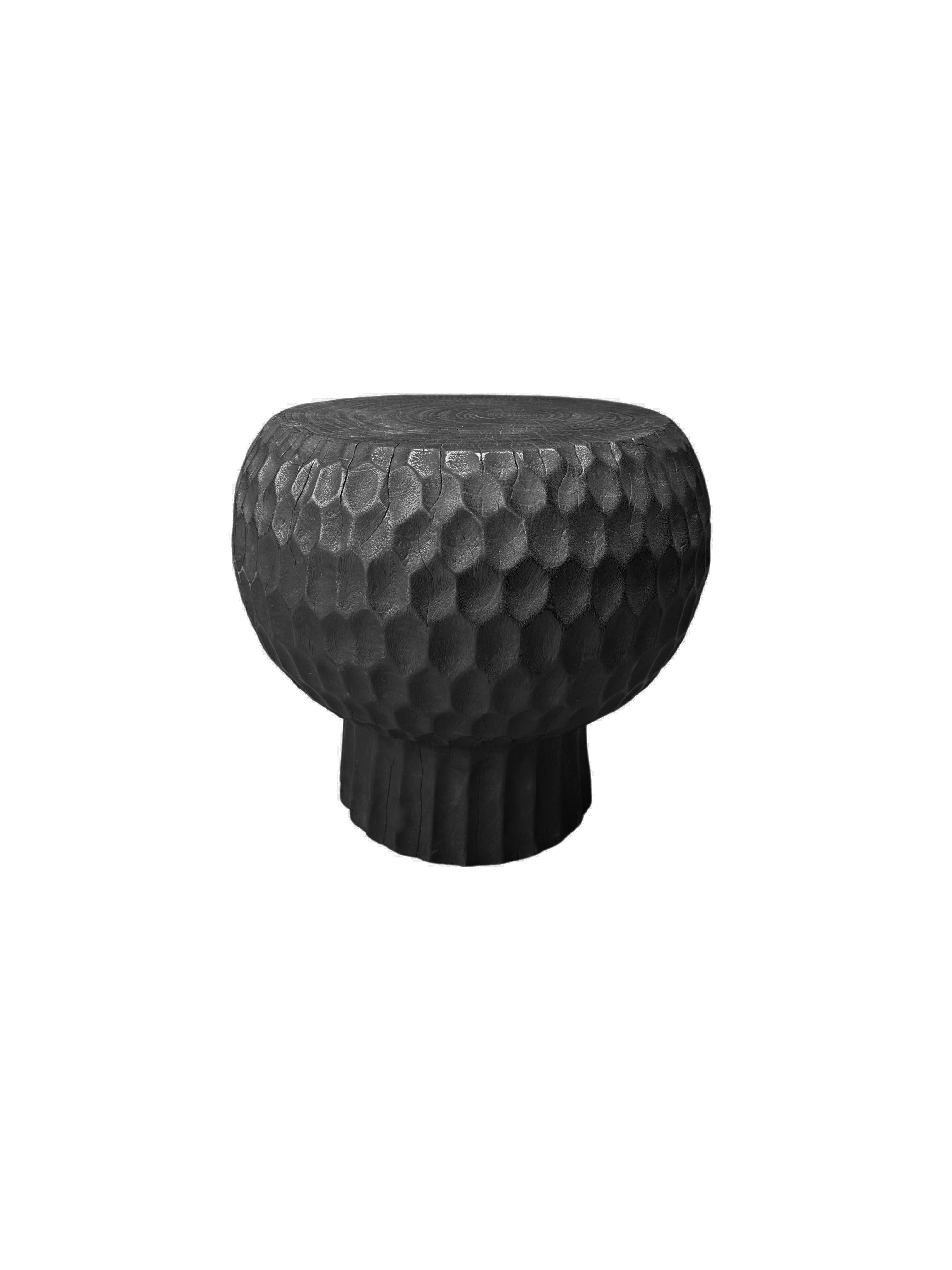 Voici notre exquise table d'appoint ronde, fabriquée de manière experte en bois de manguier. Cette pièce étonnante présente des détails géométriques complexes sculptés à la main sur ses côtés, mettant en valeur l'habileté de l'artisan et ajoutant