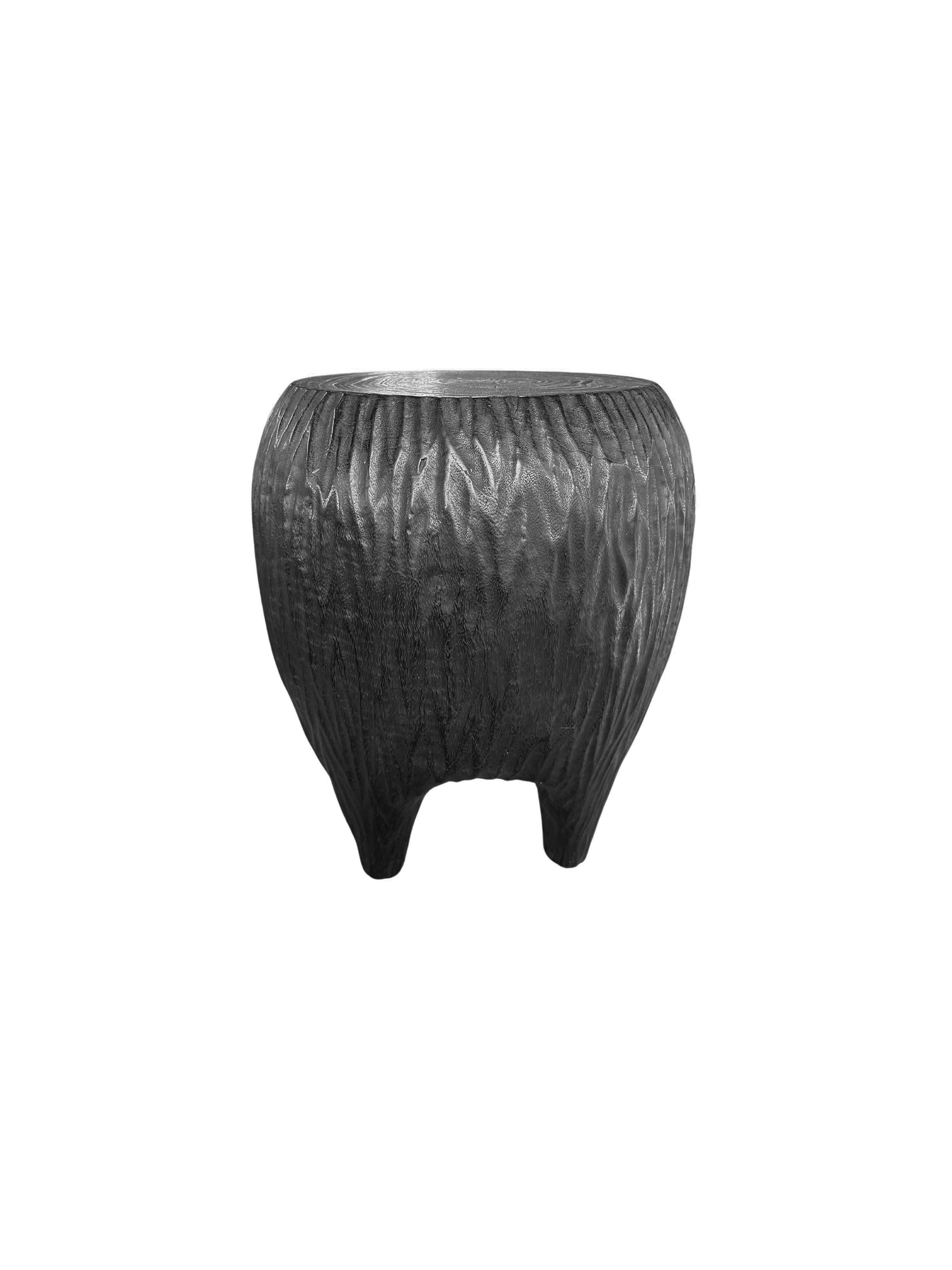 Voici une étonnante table d'appoint sculpturale en bois de manguier qui allie admirablement l'art et la fonctionnalité. Cette pièce exquise présente des côtés sculptés de manière complexe qui mettent en valeur le grain naturel du bois, ajoutant
