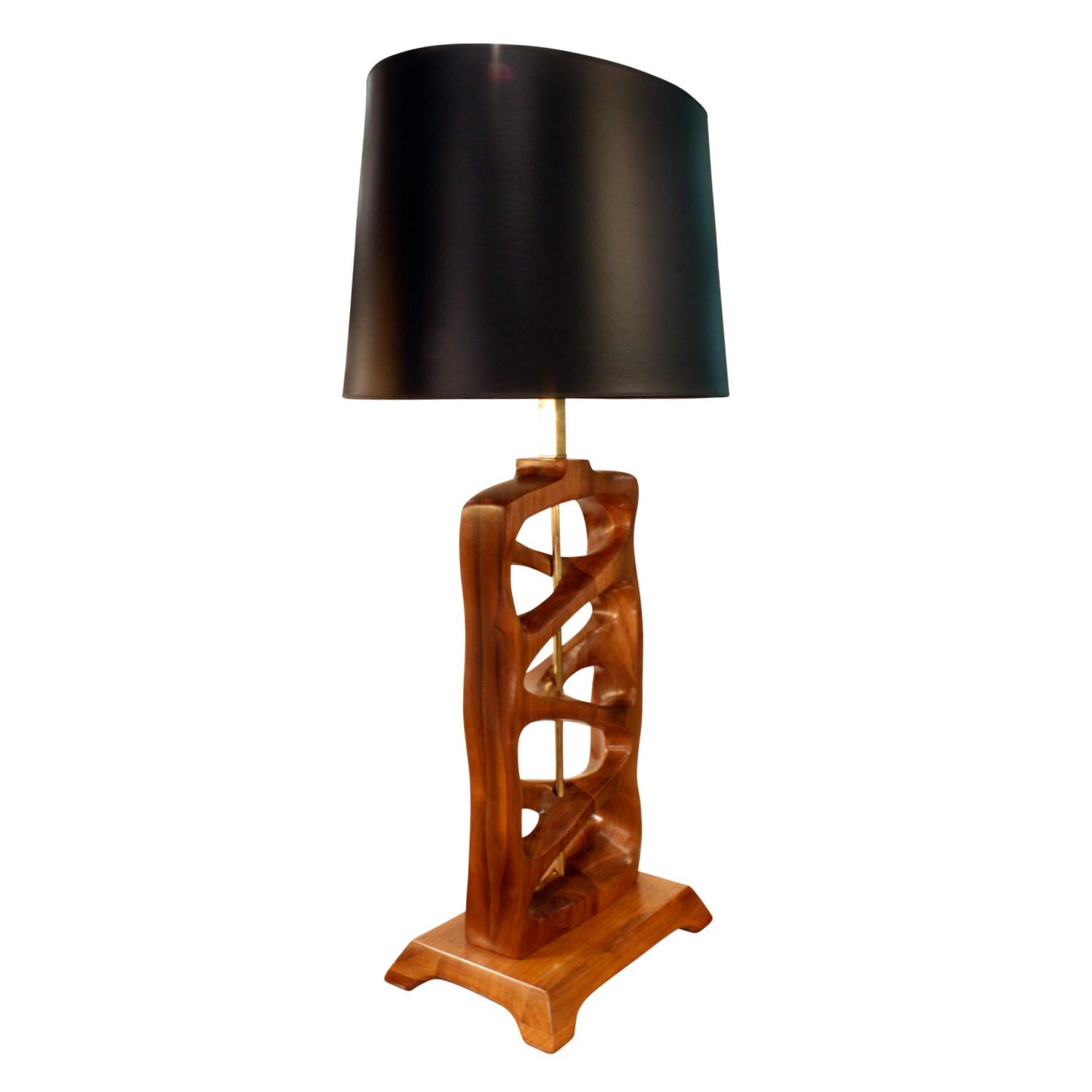 Artisan table lamp with hand carved walnut design, American, 1950s.

Measures: Shade W: 18 inches
Shade D: 13 inches.