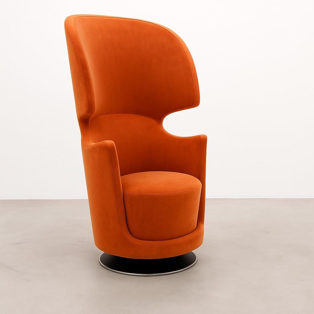 This armchair is designed for both comfort and a sense of personal space.  The high back and shell-like shape provide a feeling of enclosure, creating a quiet and private haven ideal for relaxing alone or enjoying a conversation with a companion. 