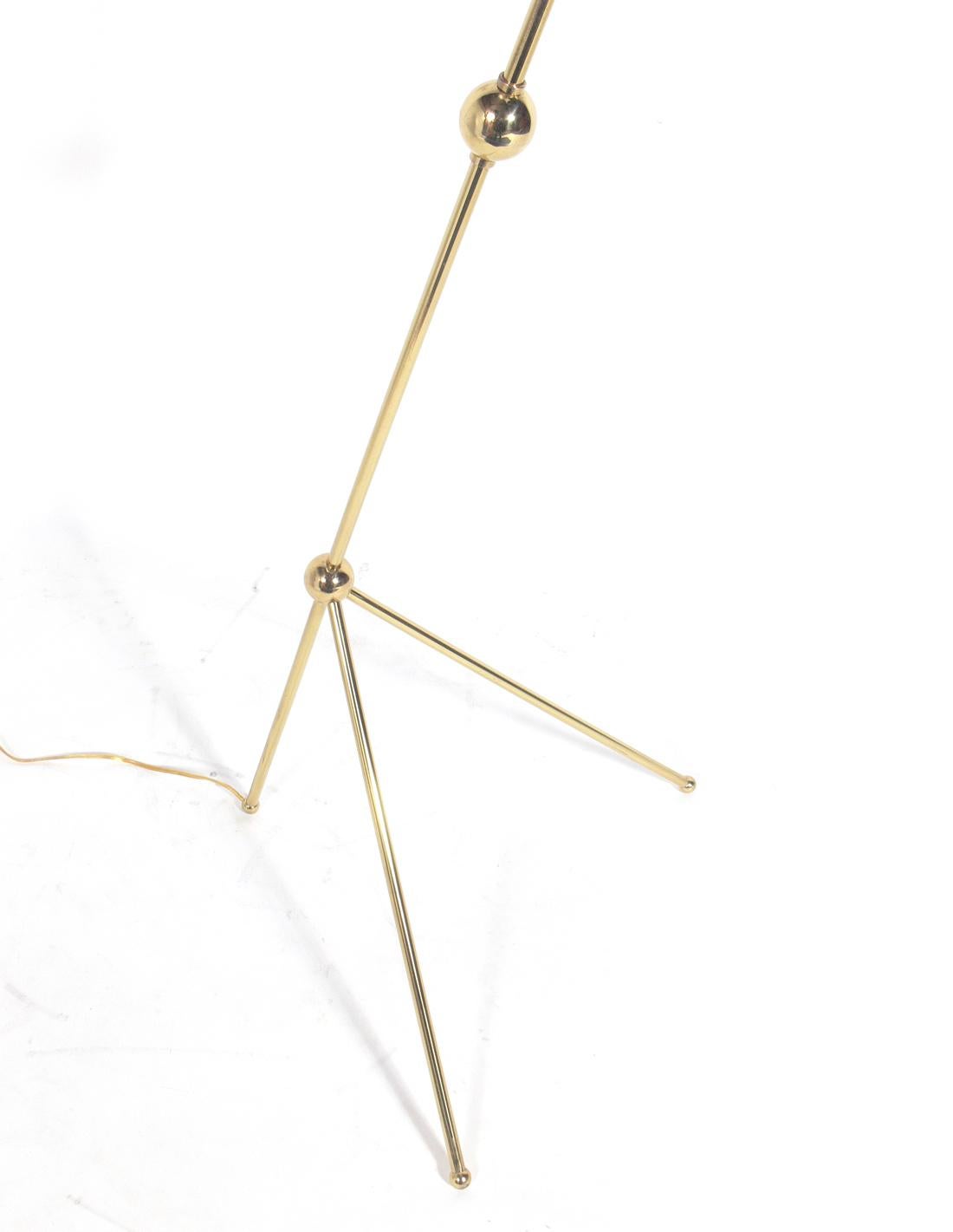 Sculptural Italian floor lamp, attributed to Stilnovo, American, circa 1950s. Cone shade swivels and has bulbs on both ends. The brass has been polished and lacquered. Rewired and ready to use.