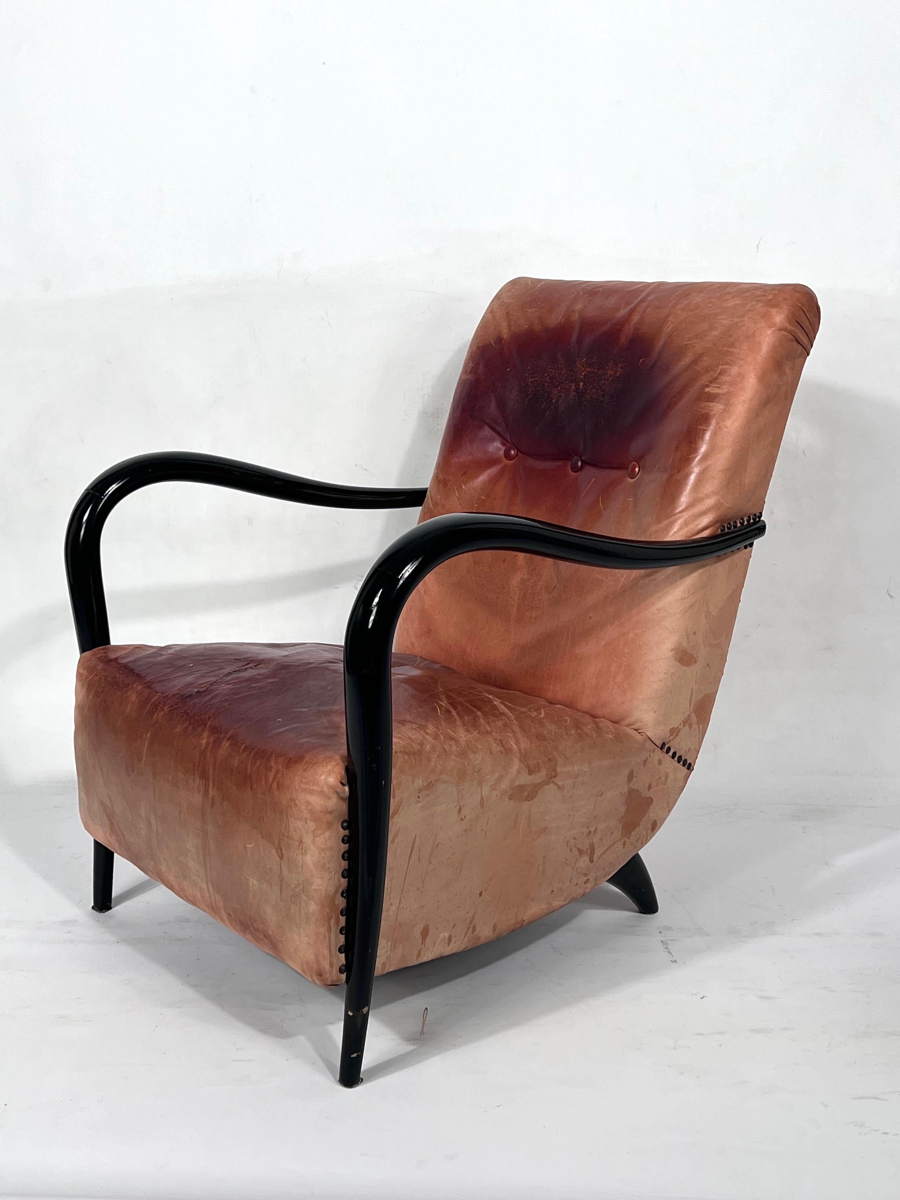 Single armchair produced in Italy during the 50s and made from curved wood and vintage real leather. Wood in good general condition. Leather with evident trace of age and use and a cut repaired.